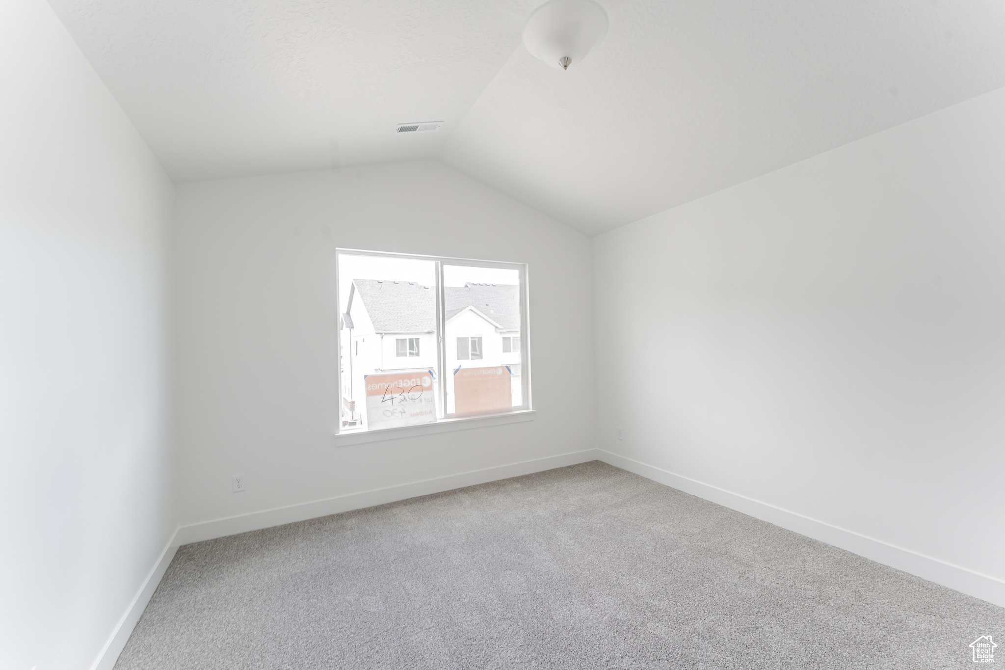 Spare room with lofted ceiling and carpet flooring
