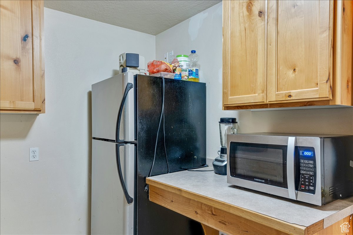 Kitchen with light brown cabinetry and stainless steel appliances