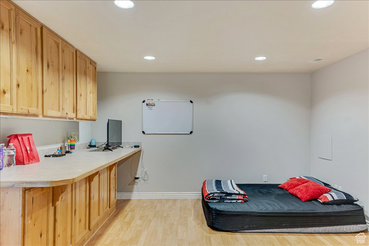 Interior space with light wood-type flooring, kitchen peninsula, and built in desk