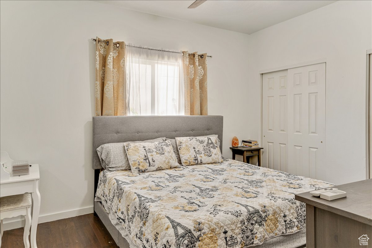 Bedroom featuring a closet, dark wood-type flooring, and ceiling fan