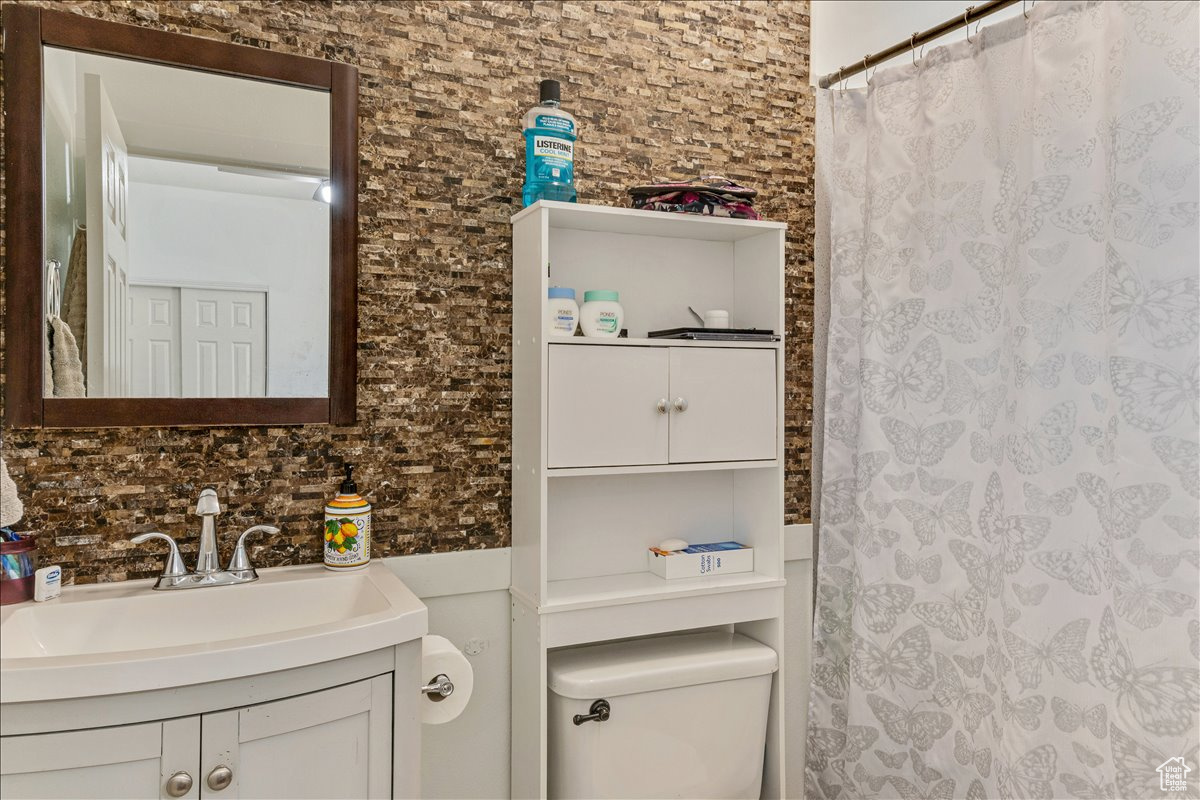 Bathroom with vanity, toilet, and backsplash