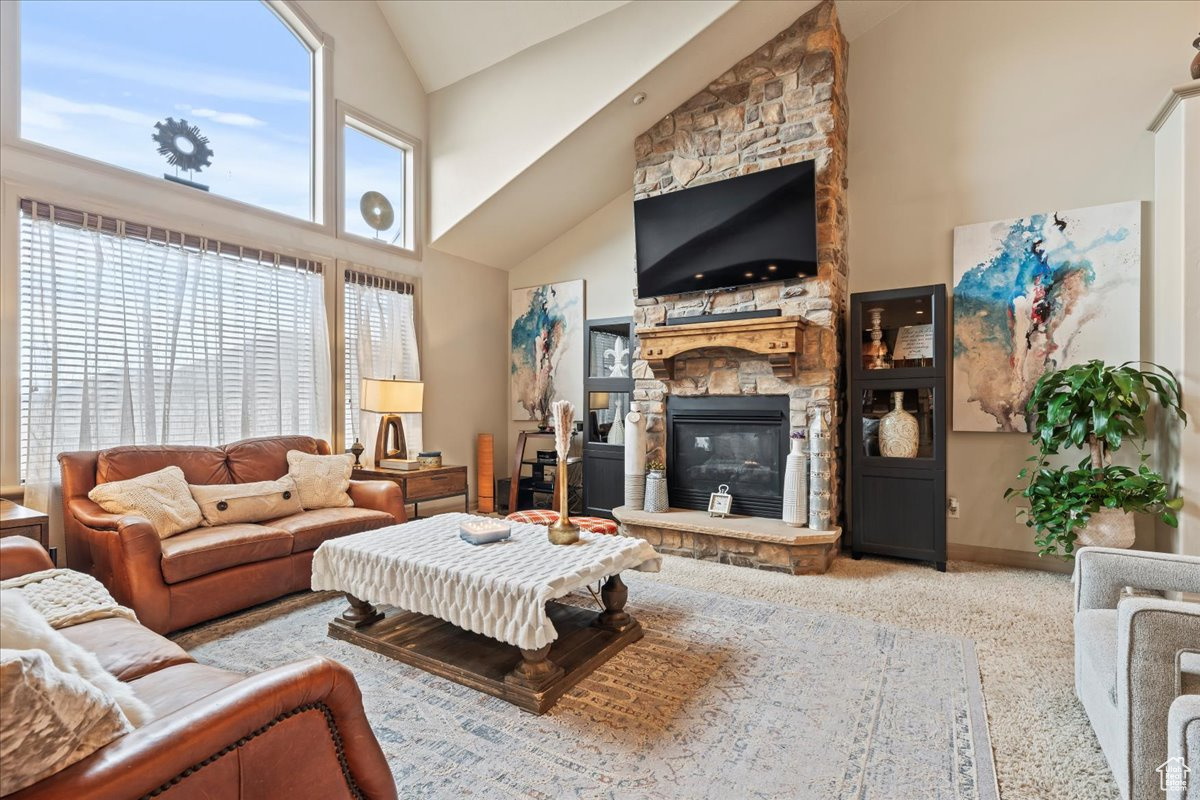 Living room featuring high vaulted ceiling and a fireplace