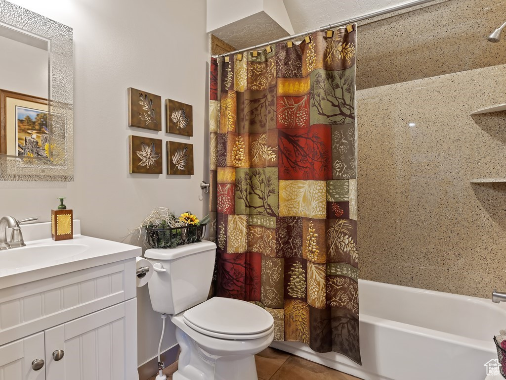 Full bathroom featuring tile floors, vanity, toilet, and shower / bath combo with shower curtain