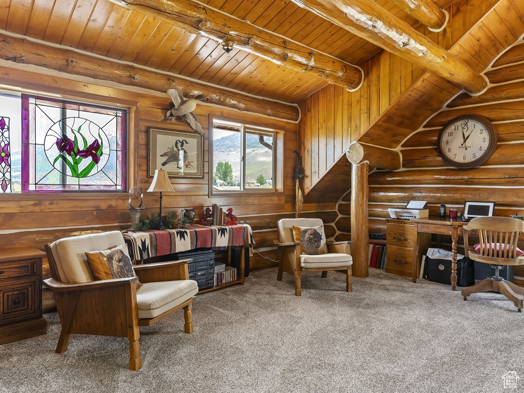 Living area with log walls, carpet floors, beamed ceiling, and wood ceiling