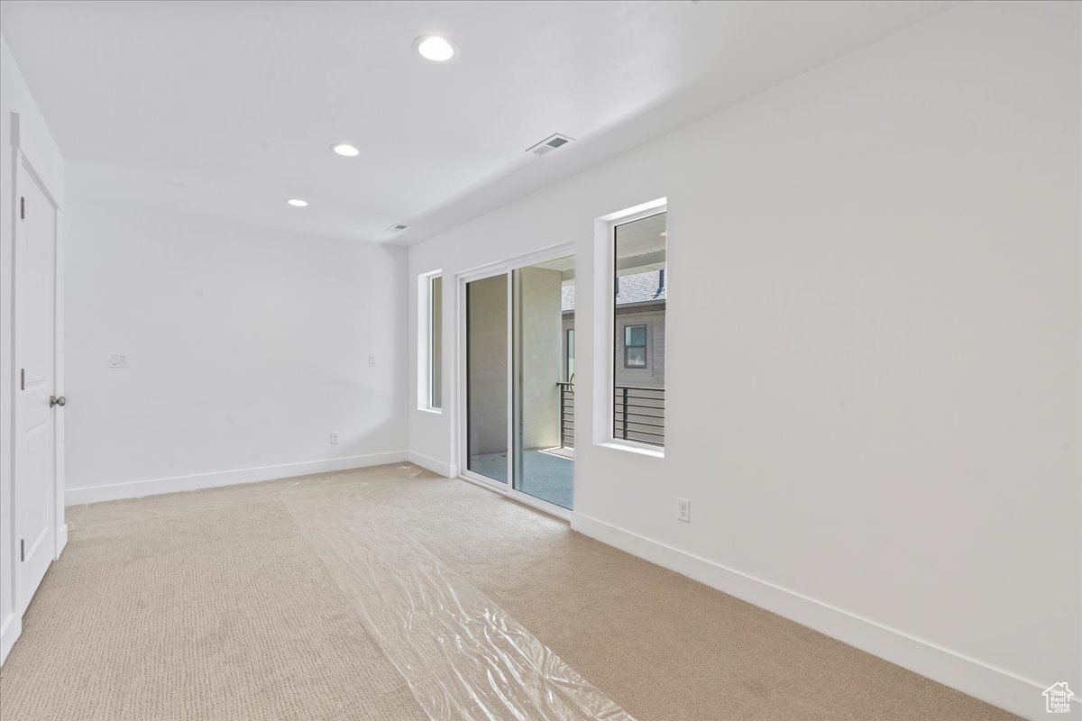 Empty room featuring light carpet