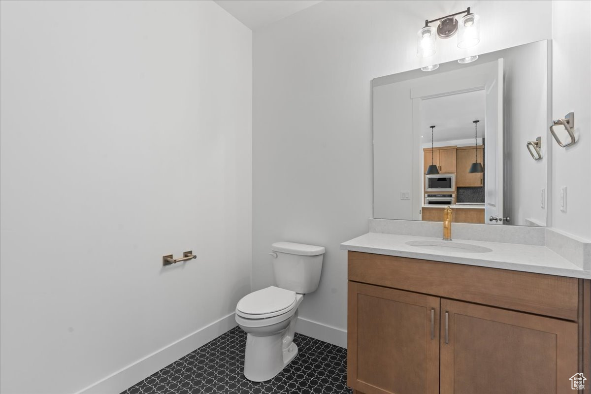 Bathroom with vanity, toilet, and tile patterned floors