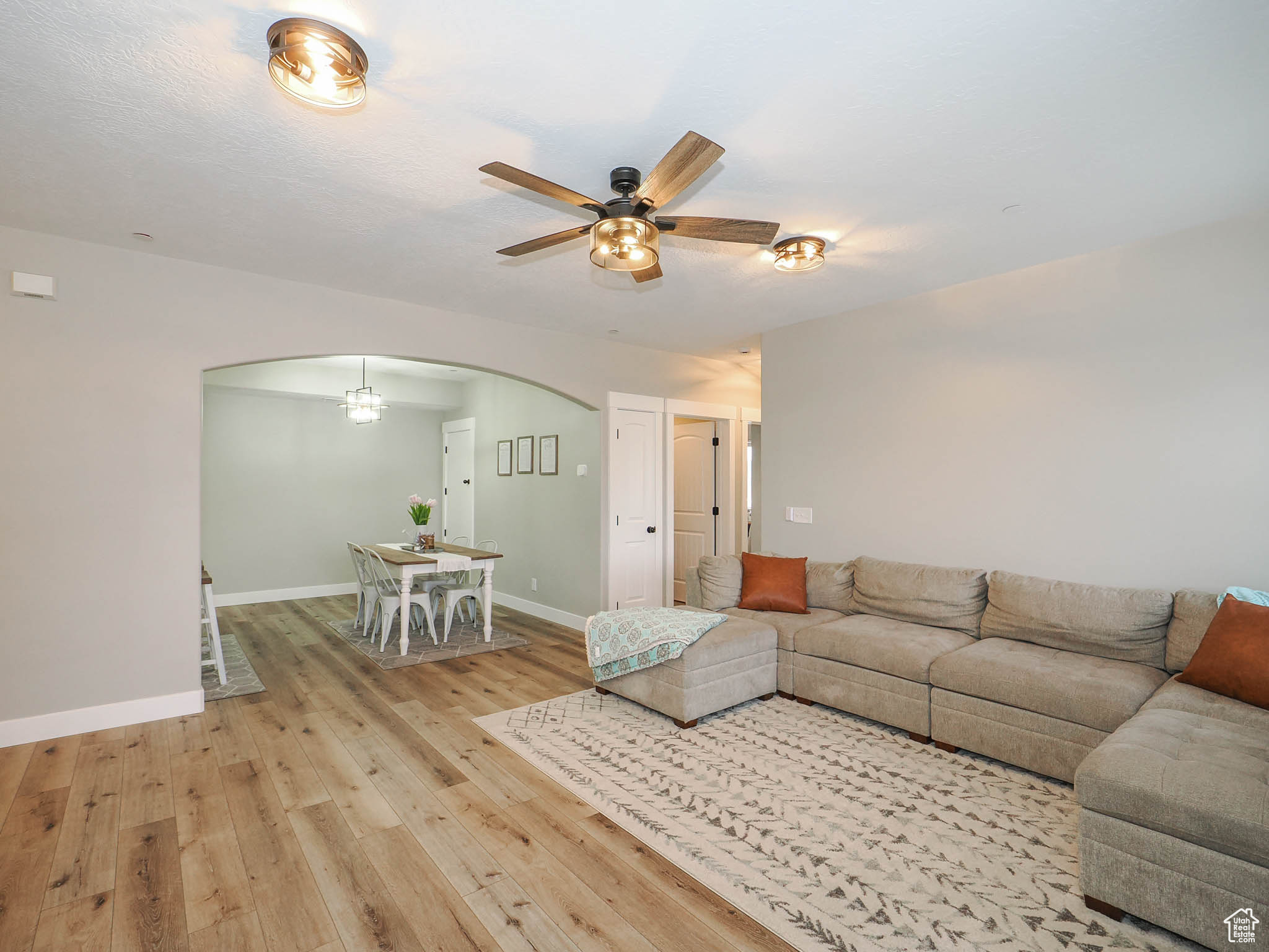 Unfurnished living room featuring light wood-type flooring and ceiling fan