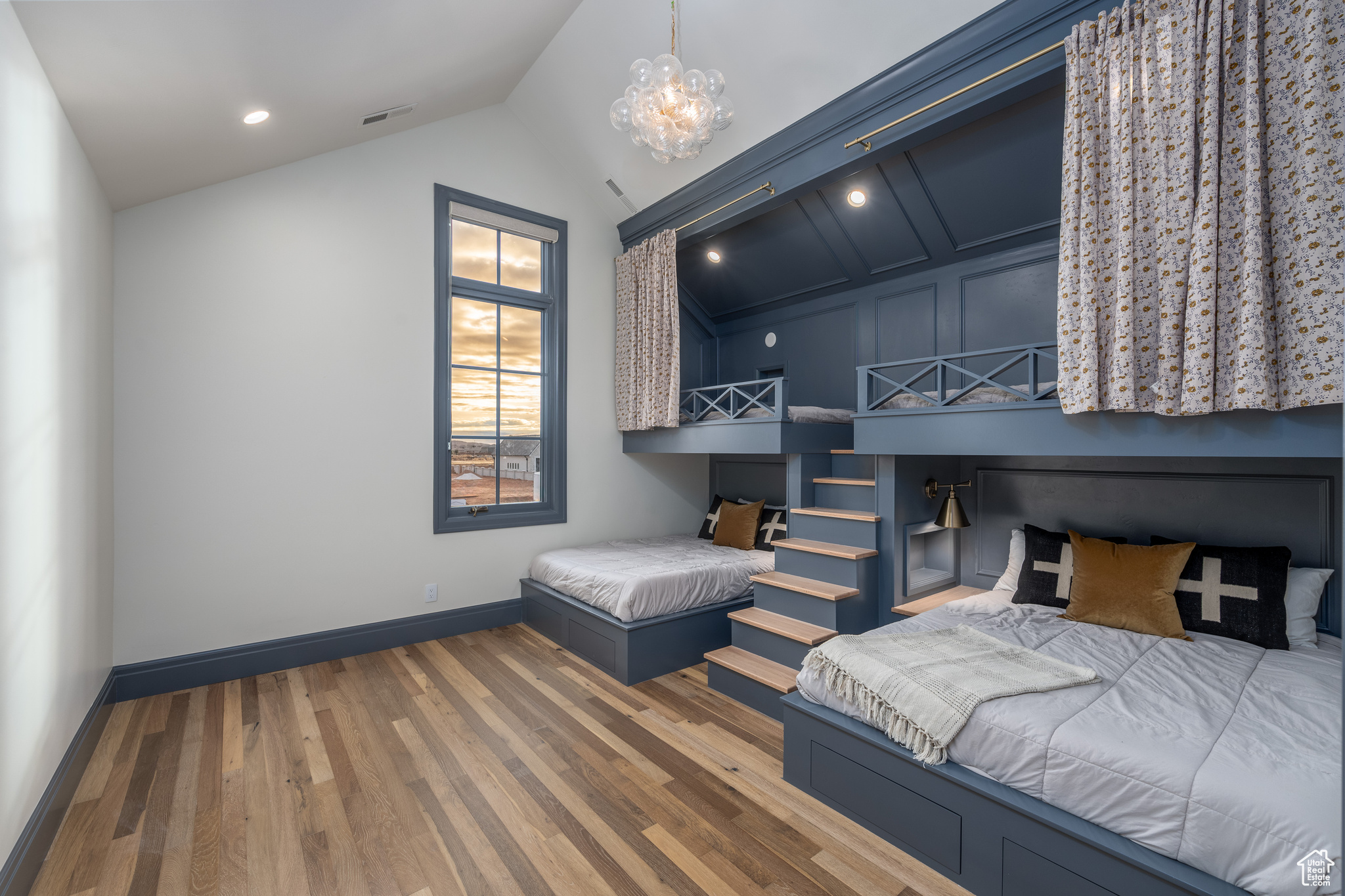 Bedroom featuring dark hardwood / wood-style flooring, a notable chandelier, and lofted ceiling