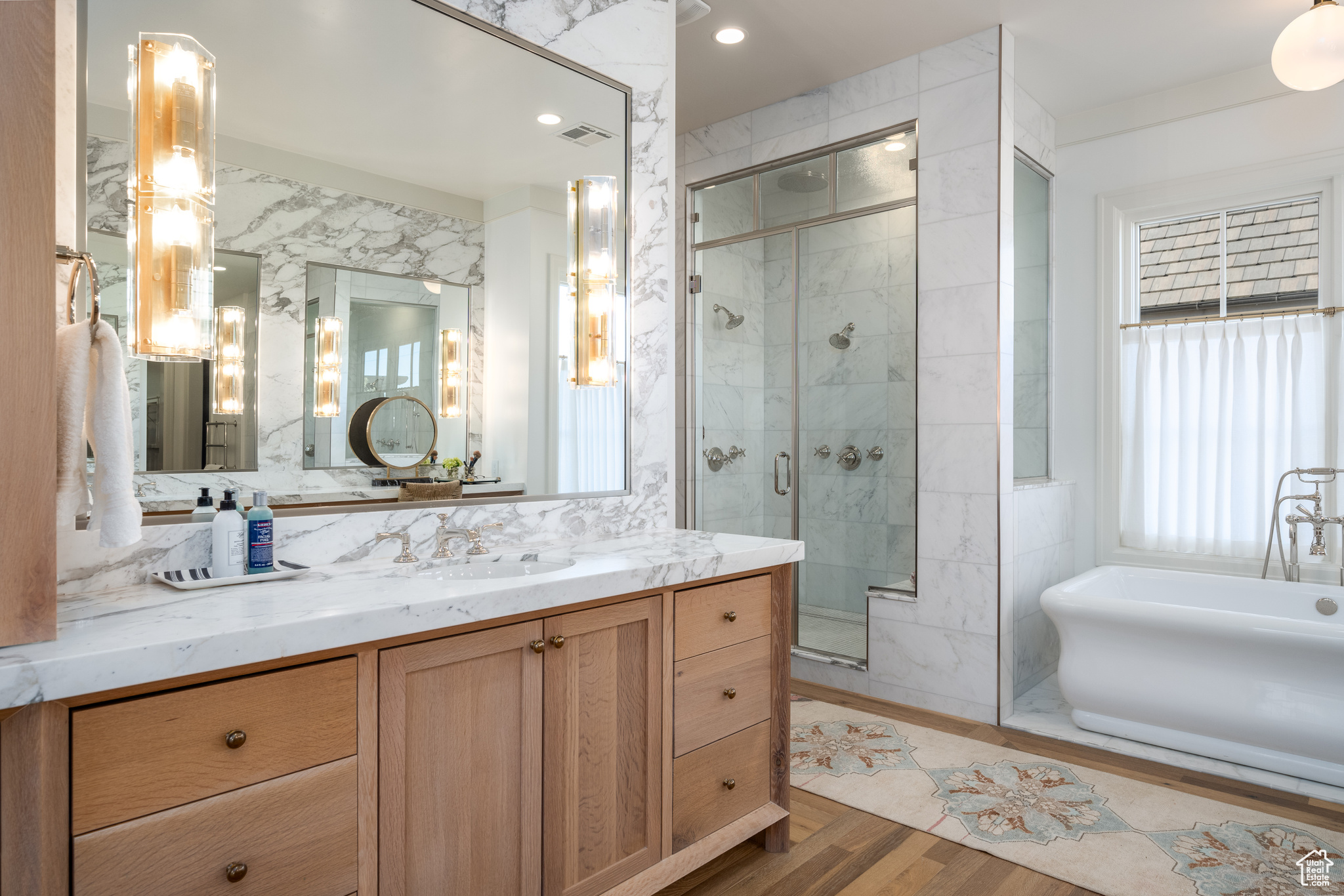 Bathroom featuring tile walls, vanity, a shower with door, and hardwood / wood-style flooring