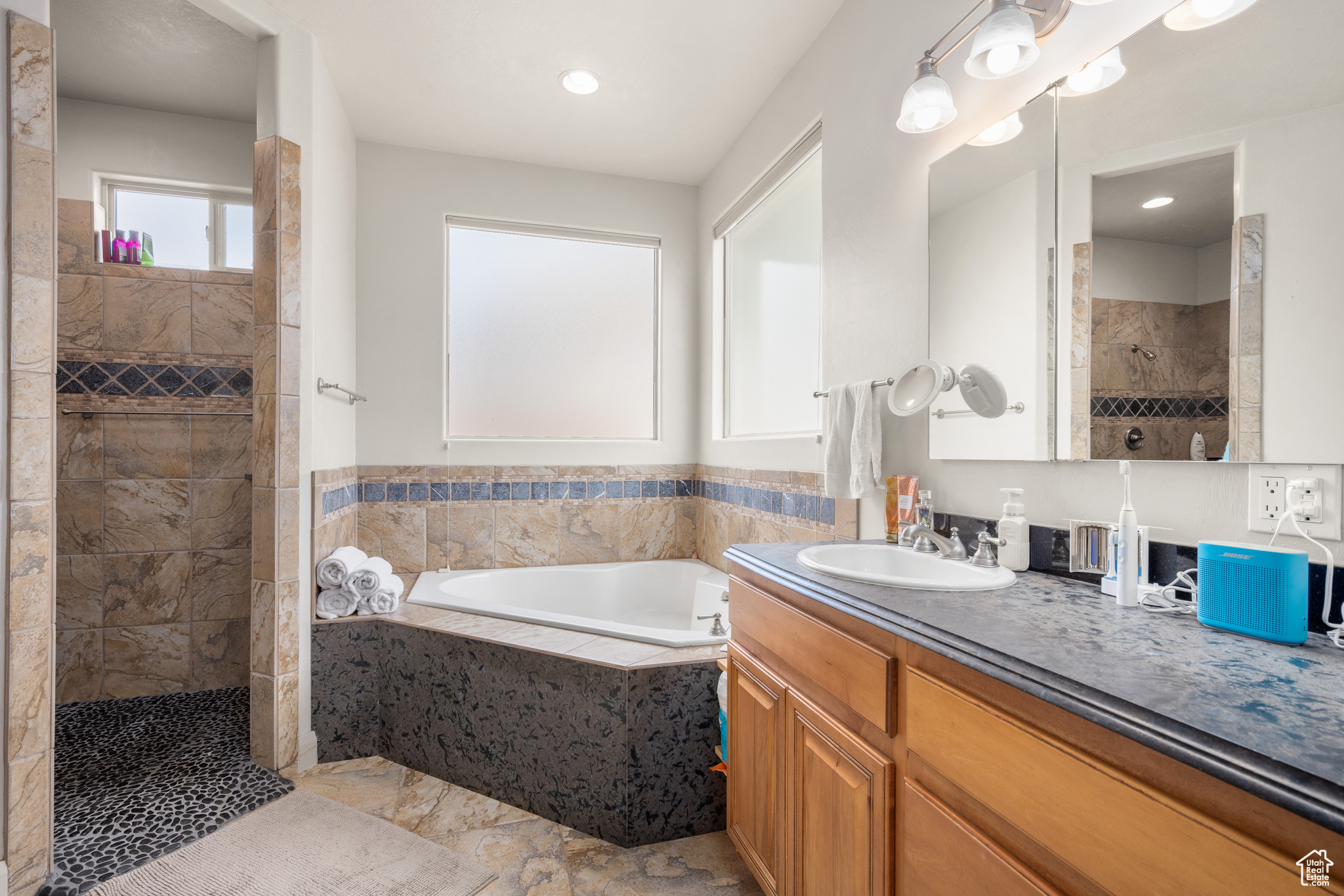 Bathroom featuring tile floors, vanity, and independent shower and bath