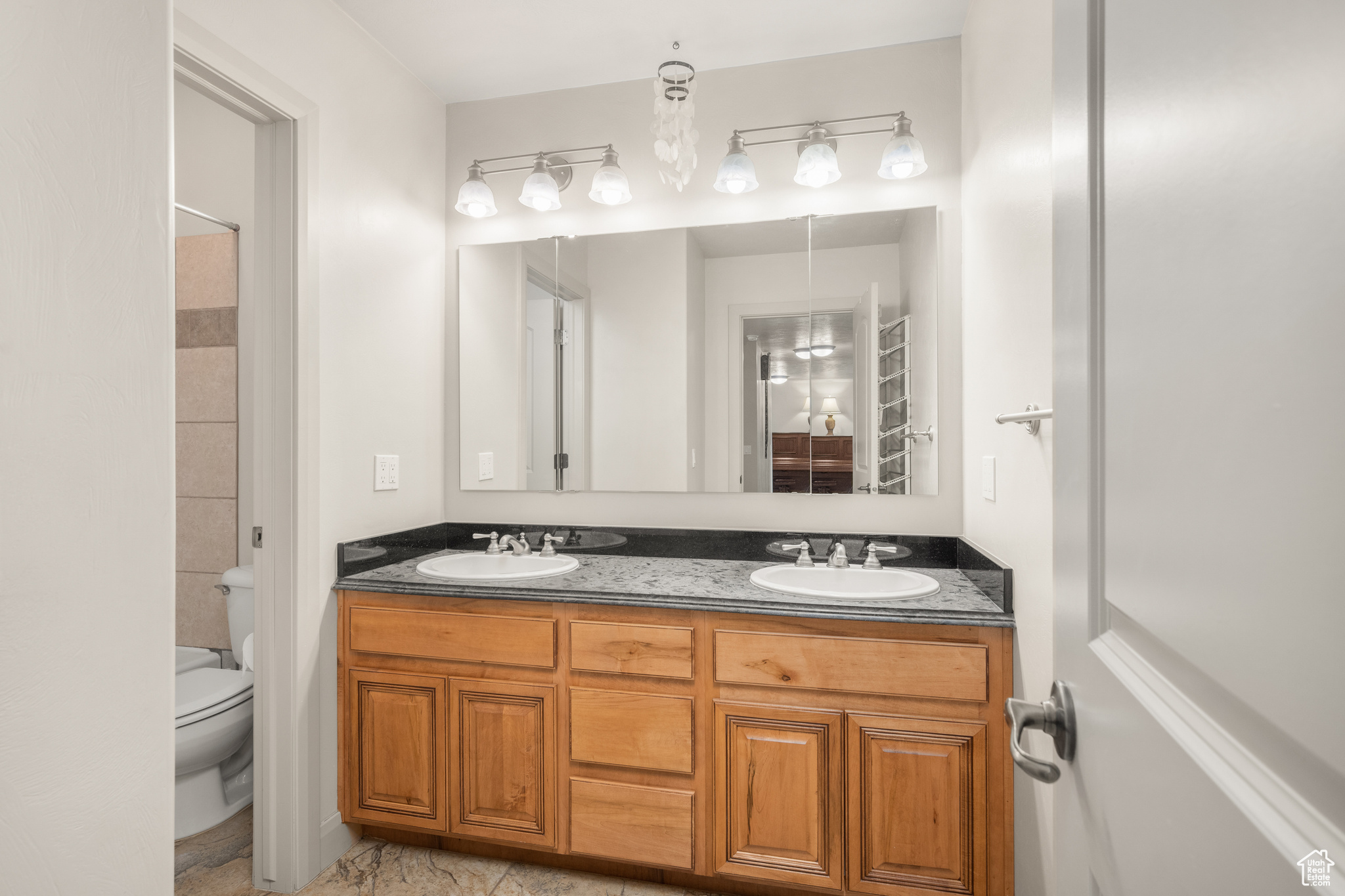 Bathroom featuring tile floors, toilet, and double sink vanity