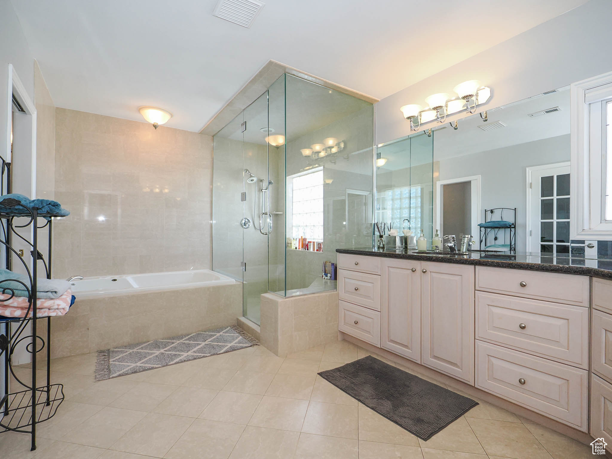 Primary Suite bathroom with double sink, separate glass enclosed shower and separate toilet room