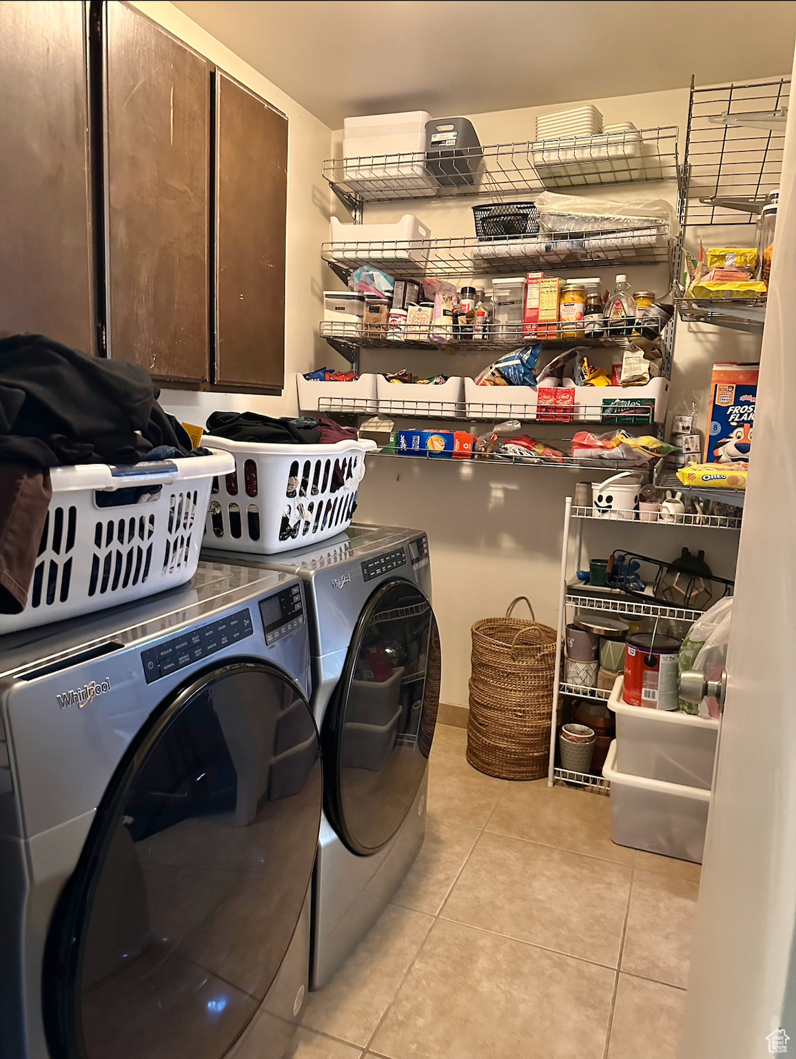 Clothes washing area featuring independent washer and dryer and light tile floors