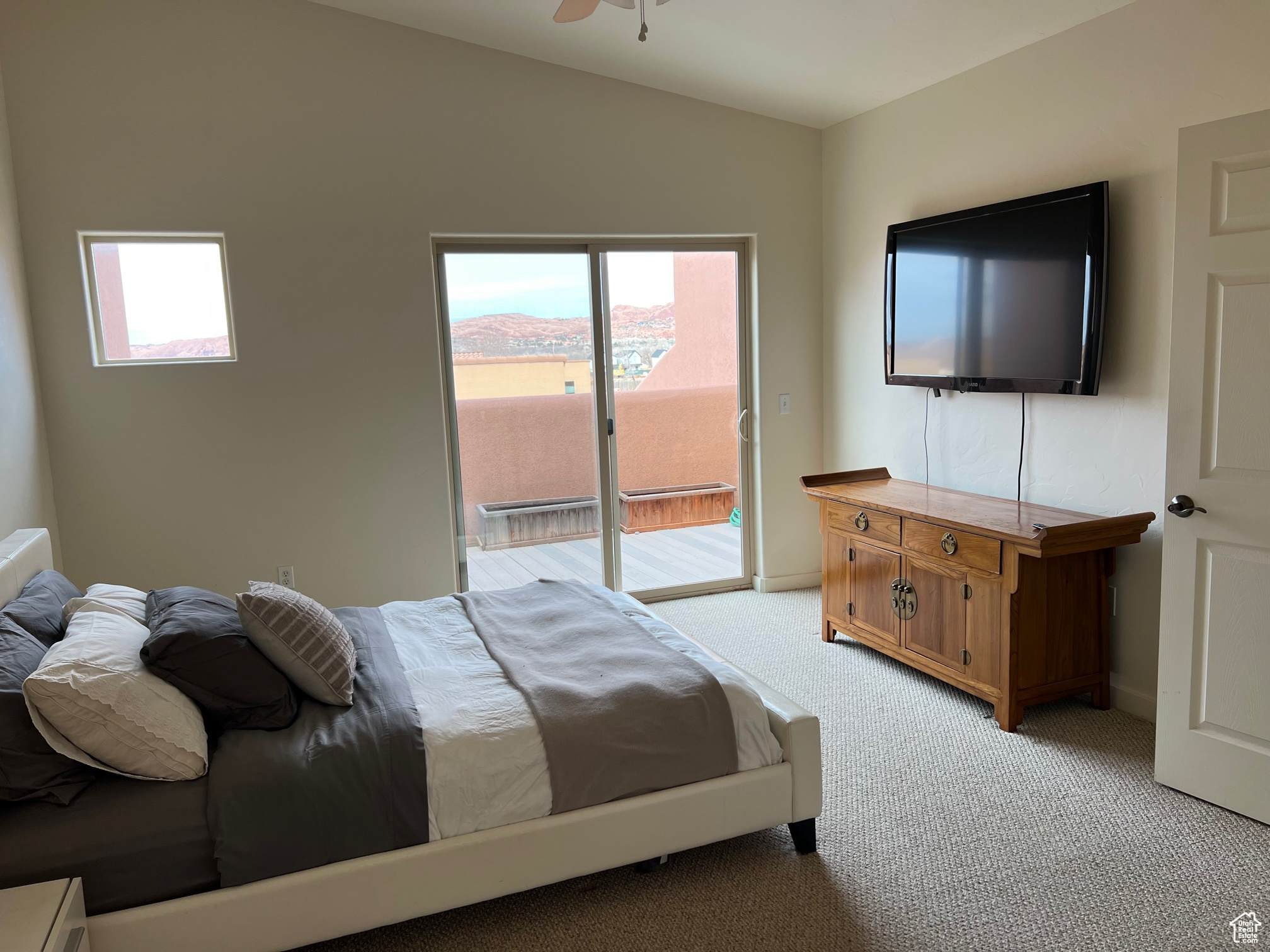 Carpeted bedroom featuring ceiling fan and access to exterior