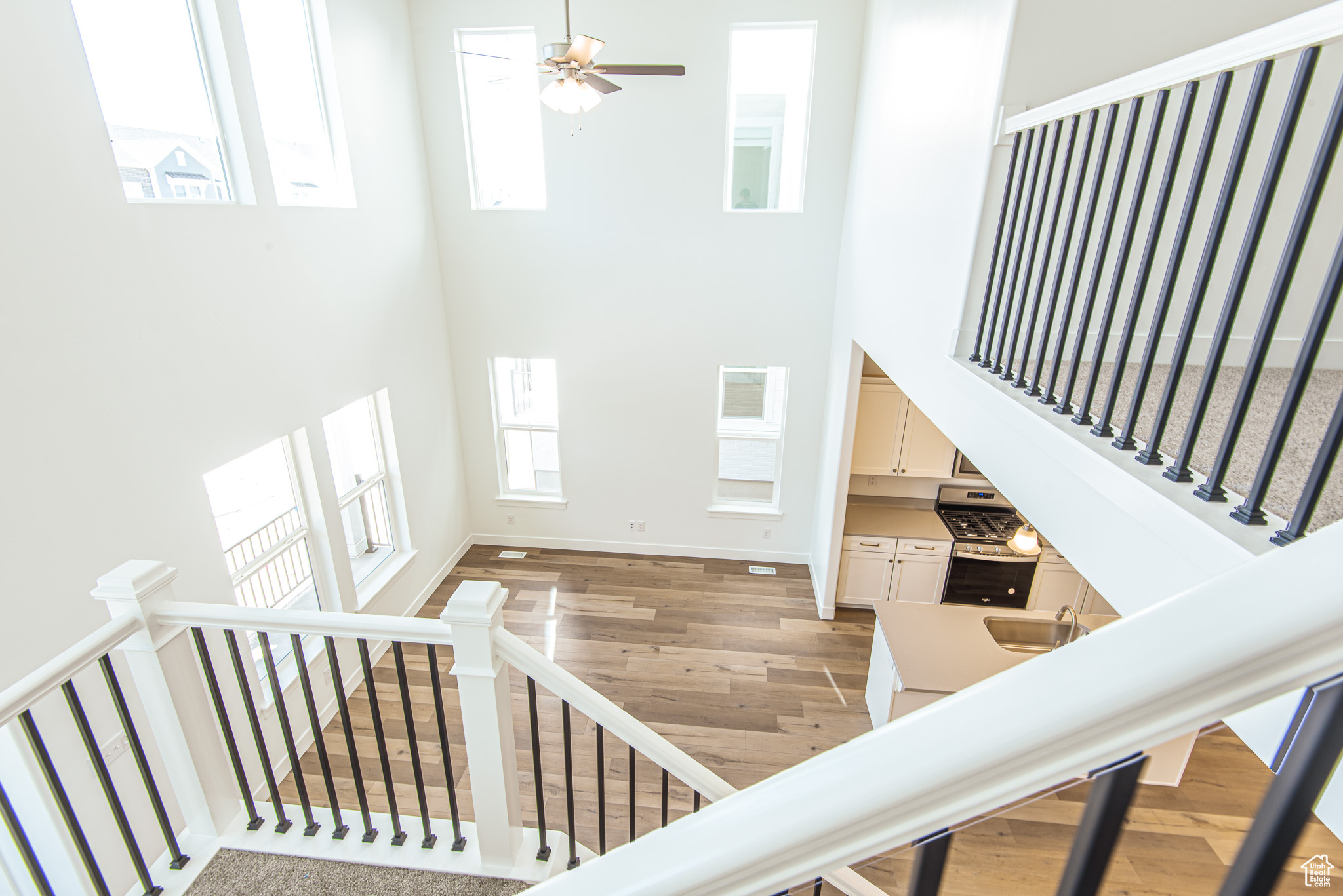 Foyer entrance featuring ceiling fan, a towering ceiling, hardwood / wood-style floors, and sink