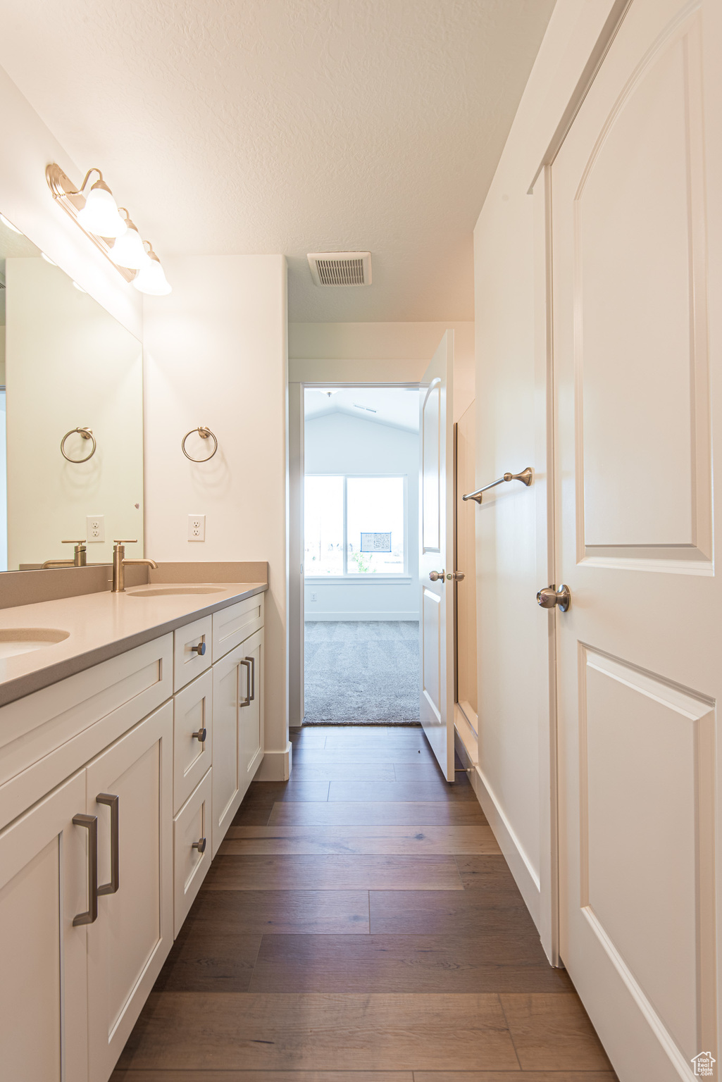 Bathroom featuring double vanity and hardwood / wood-style floors