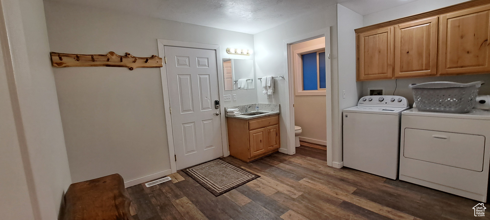 Laundry area with washer hookup, dark hardwood / wood-style flooring, washer and dryer, sink, and cabinets