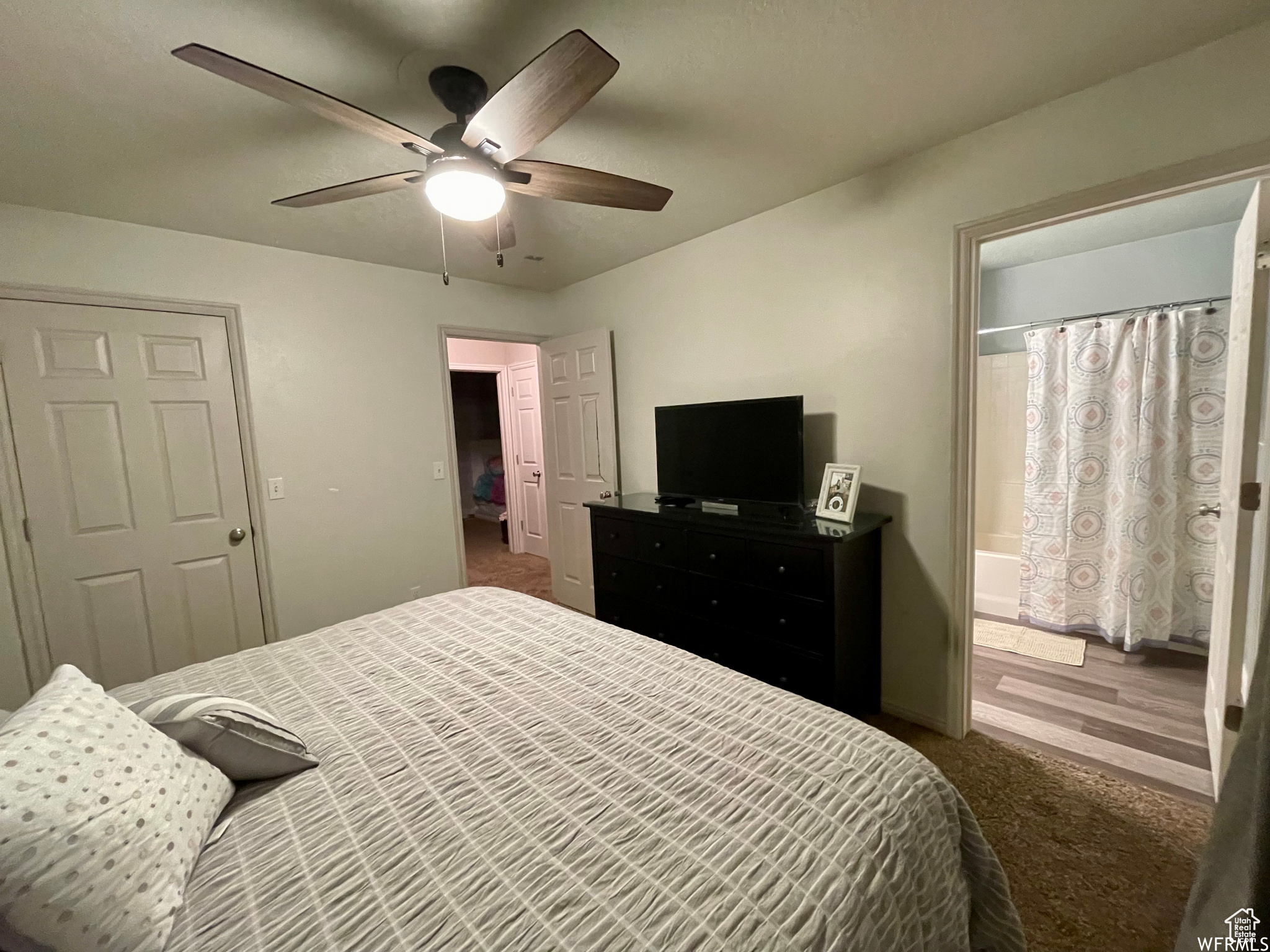 Carpeted bedroom with connected bathroom, a closet, and ceiling fan