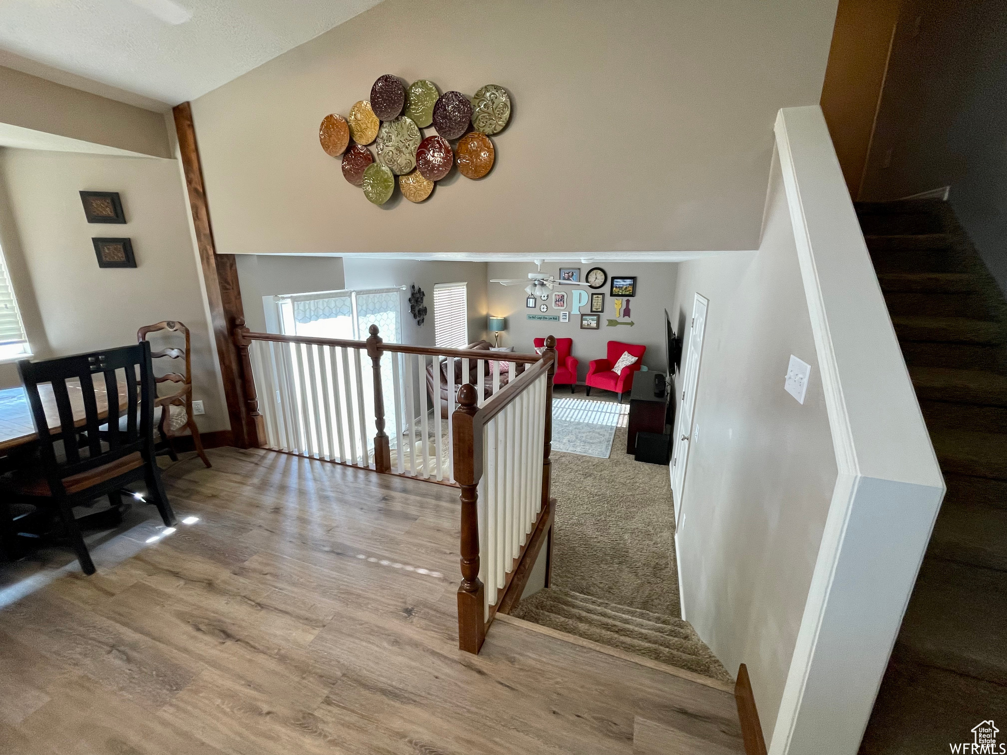 Stairs with light hardwood / wood-style flooring and lofted ceiling