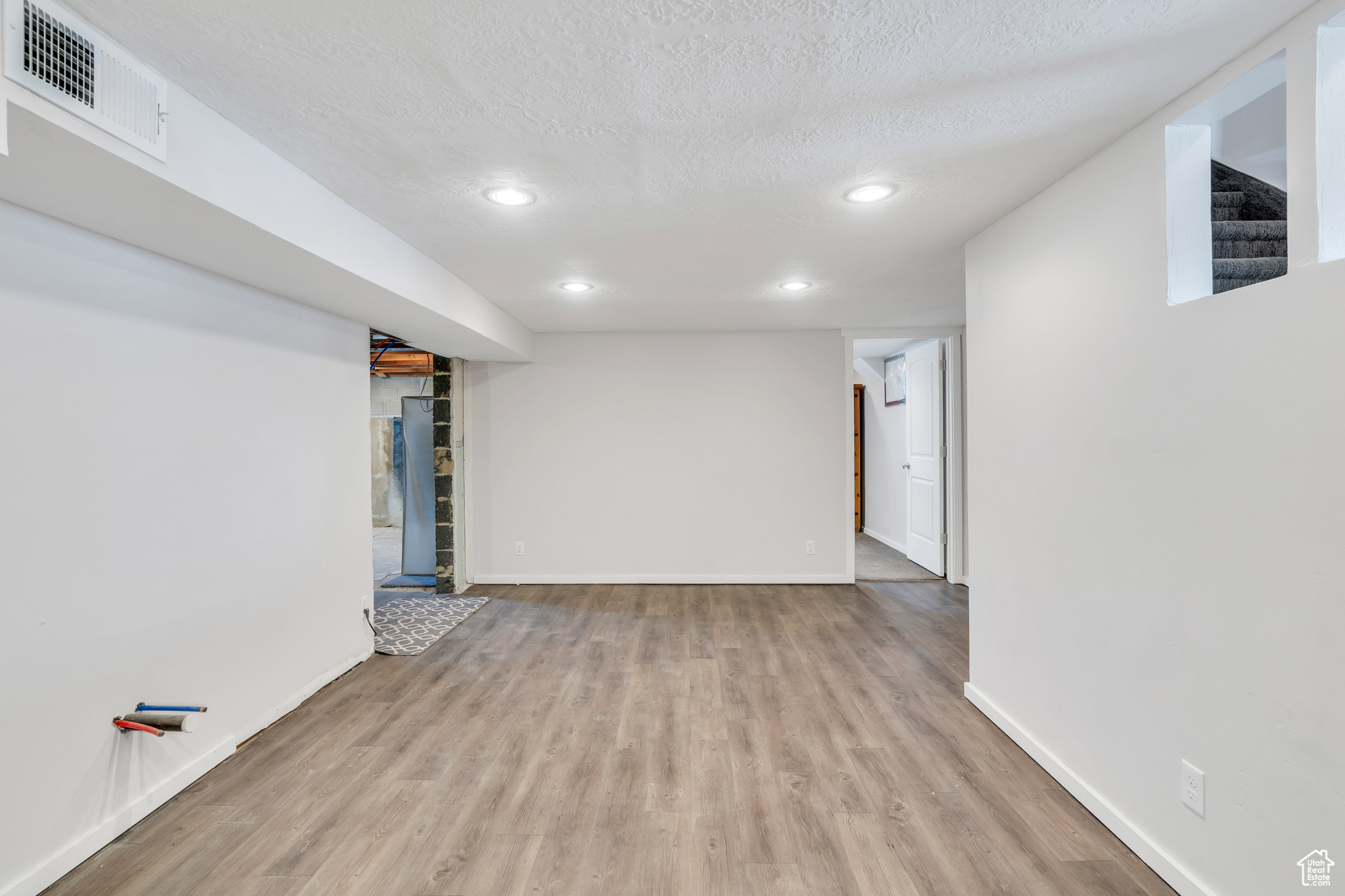 Spare room featuring light hardwood / wood-style floors and a textured ceiling