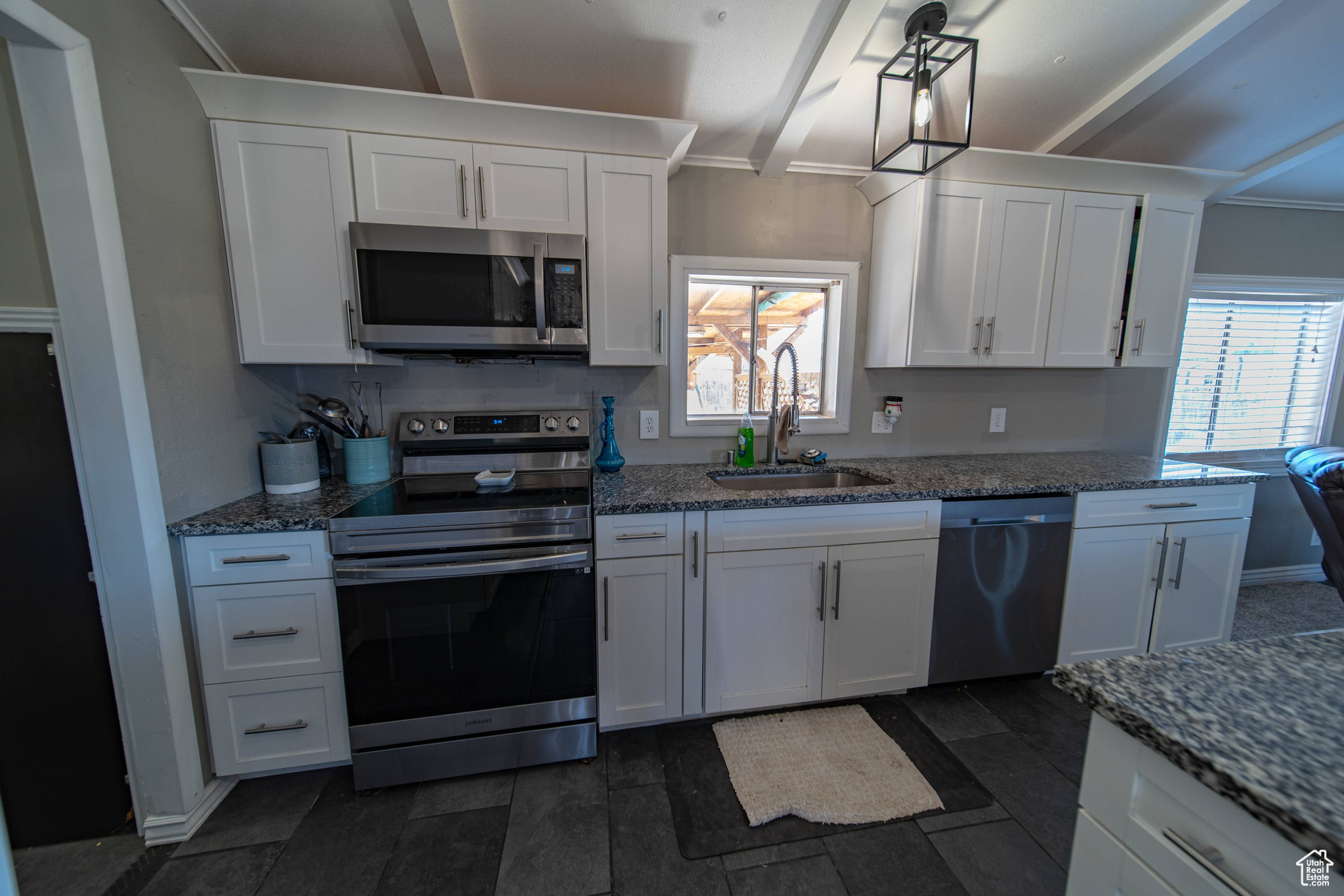 Kitchen with sink, stainless steel appliances, plenty of natural light, and white cabinetry