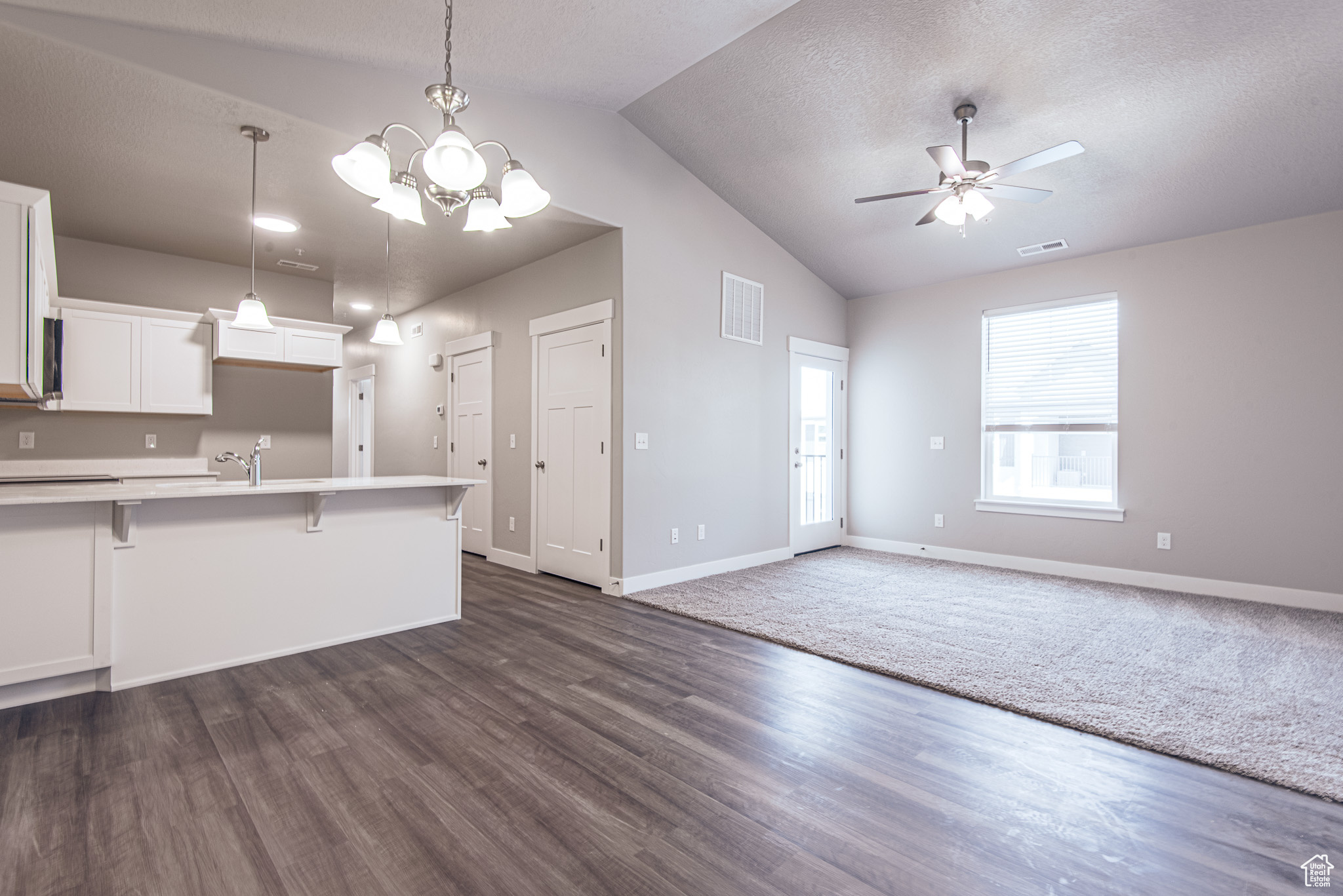 Kitchen with dark hardwood / wood-style floors, a kitchen breakfast bar, and pendant lighting