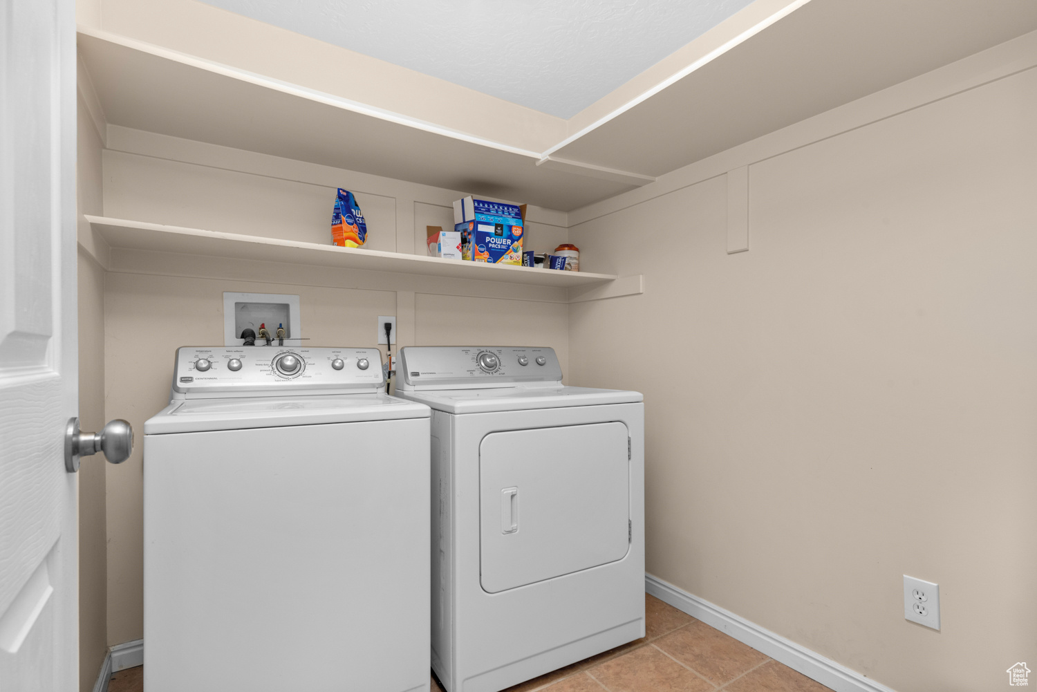 Laundry room with washer and dryer, light tile flooring, and washer hookup