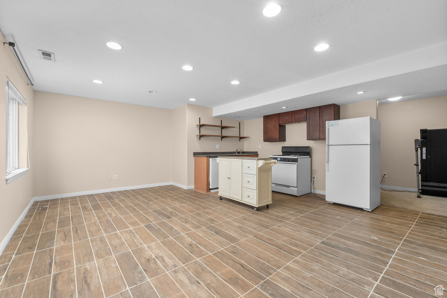 Kitchen with sink, white appliances, and light tile floors