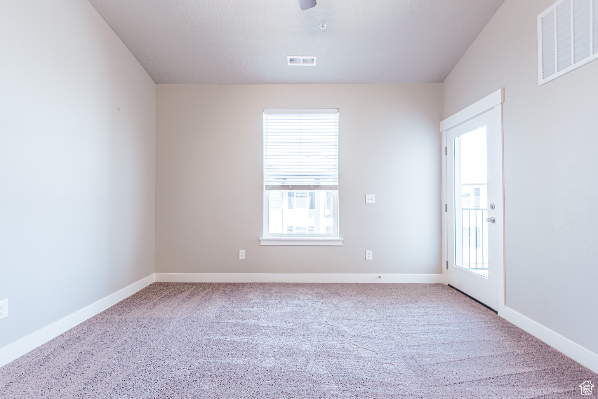 Carpeted spare room featuring plenty of natural light