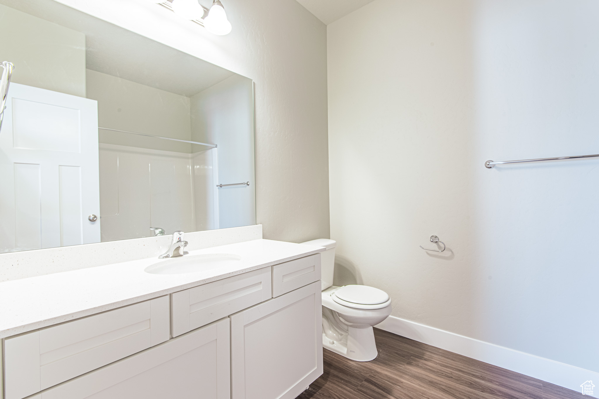 Bathroom featuring wood-type flooring, vanity, and toilet