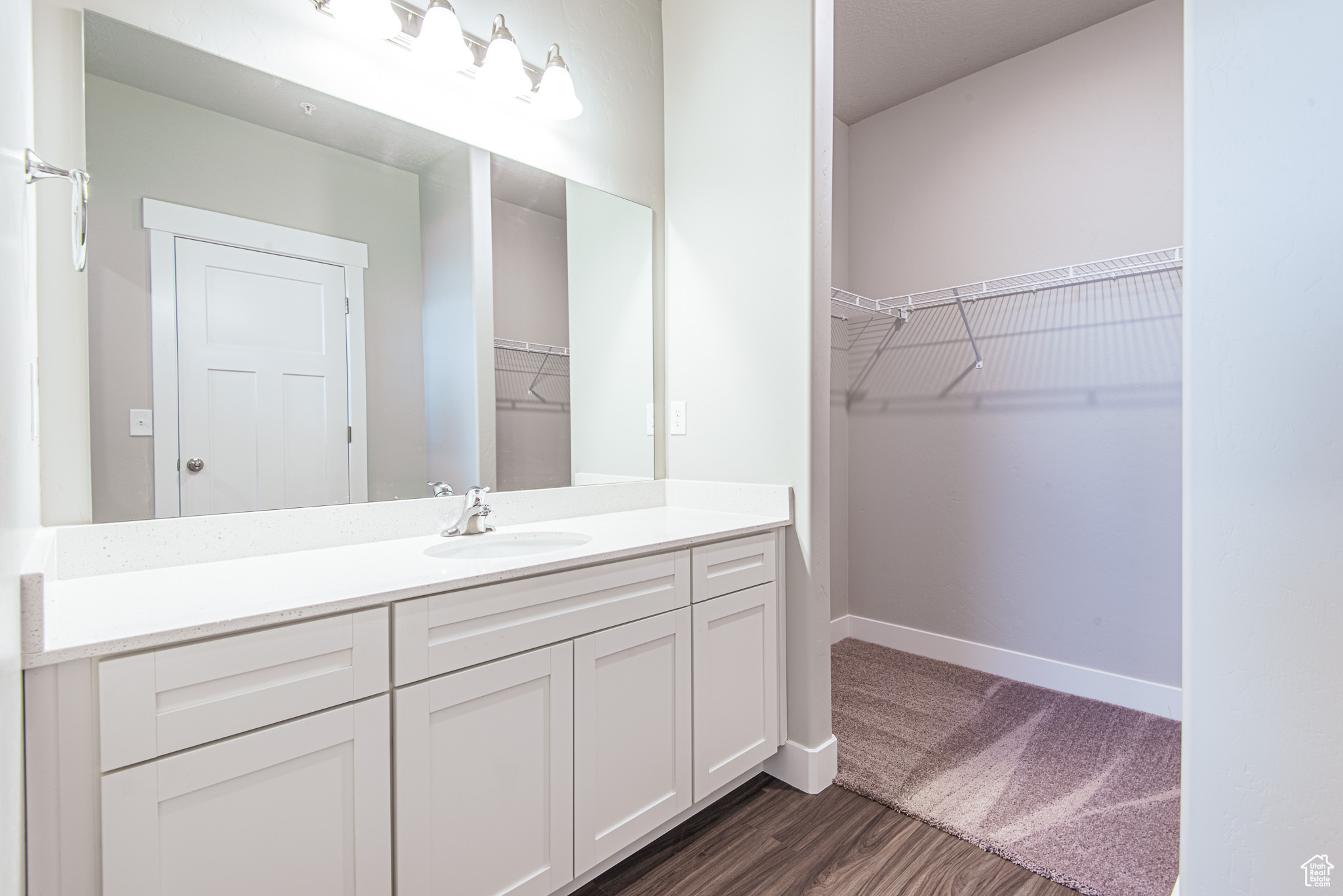 Bathroom featuring hardwood / wood-style floors and vanity with extensive cabinet space