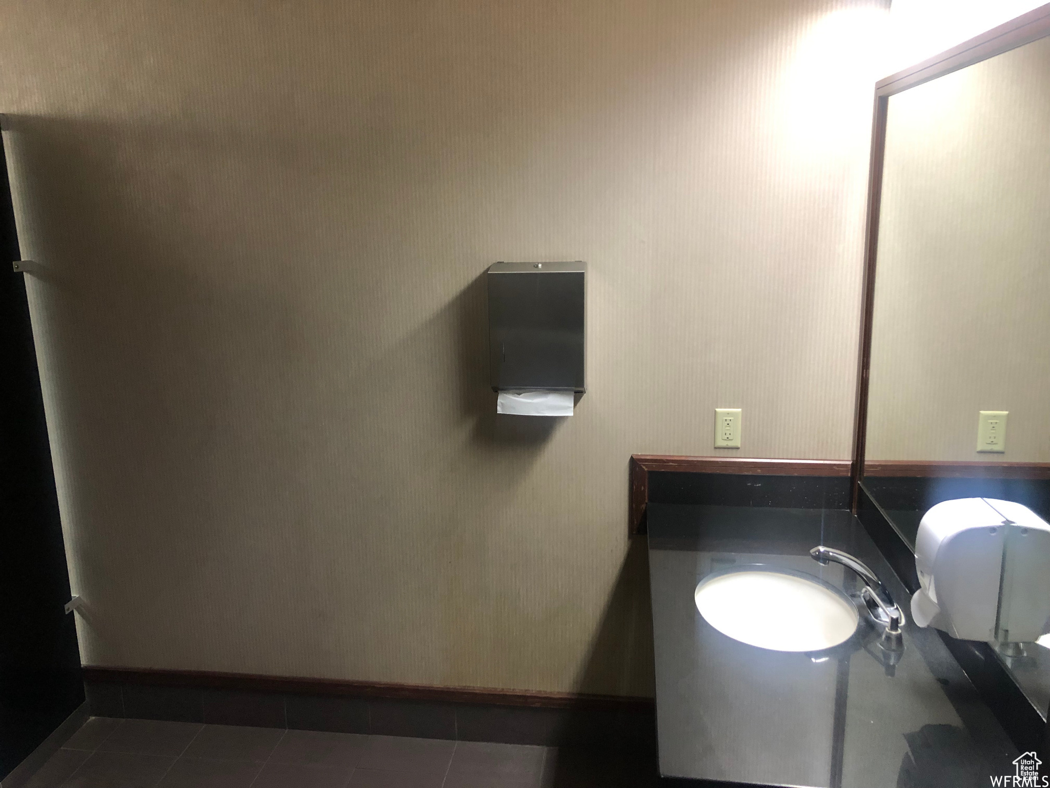 Bathroom with dark tile floors and washbasin