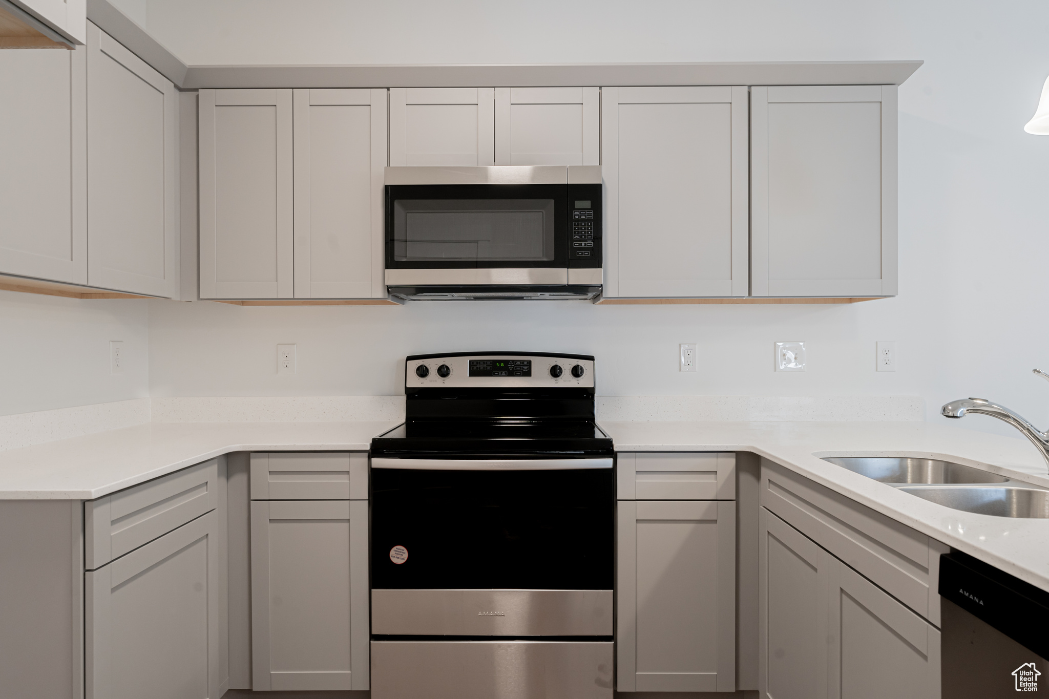 Kitchen featuring stainless steel appliances, gray cabinetry, and sink