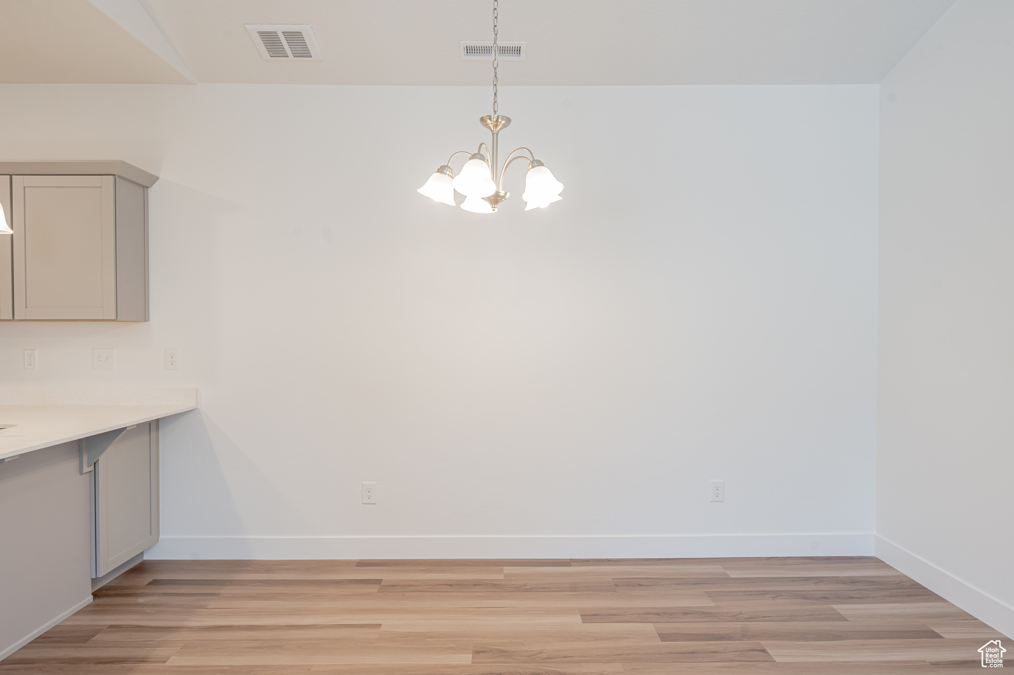 Unfurnished dining area with an inviting chandelier and light wood-type flooring