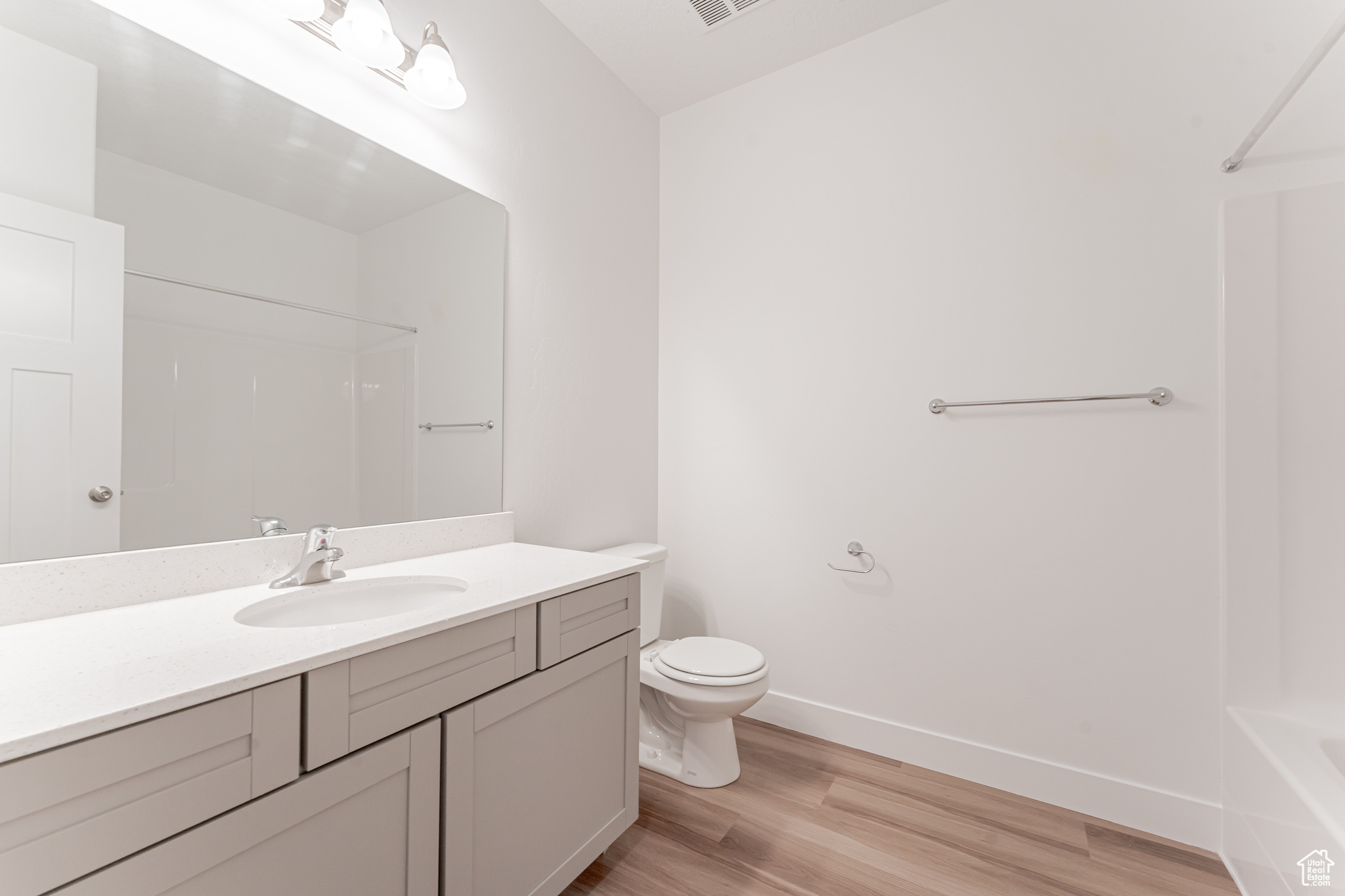 Full bathroom featuring toilet, vanity, hardwood / wood-style flooring, and shower / bathtub combination