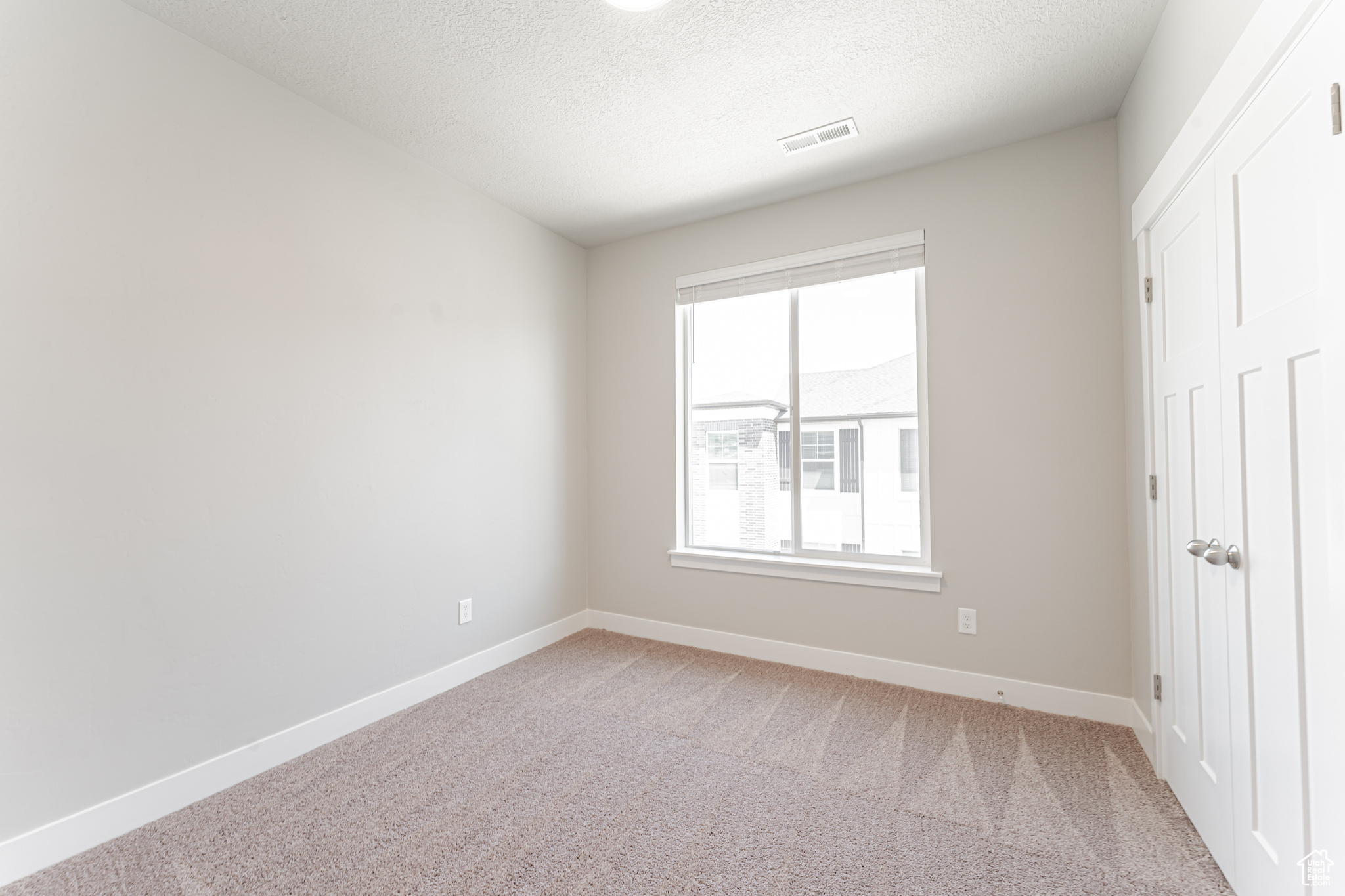 Unfurnished bedroom featuring a textured ceiling and carpet