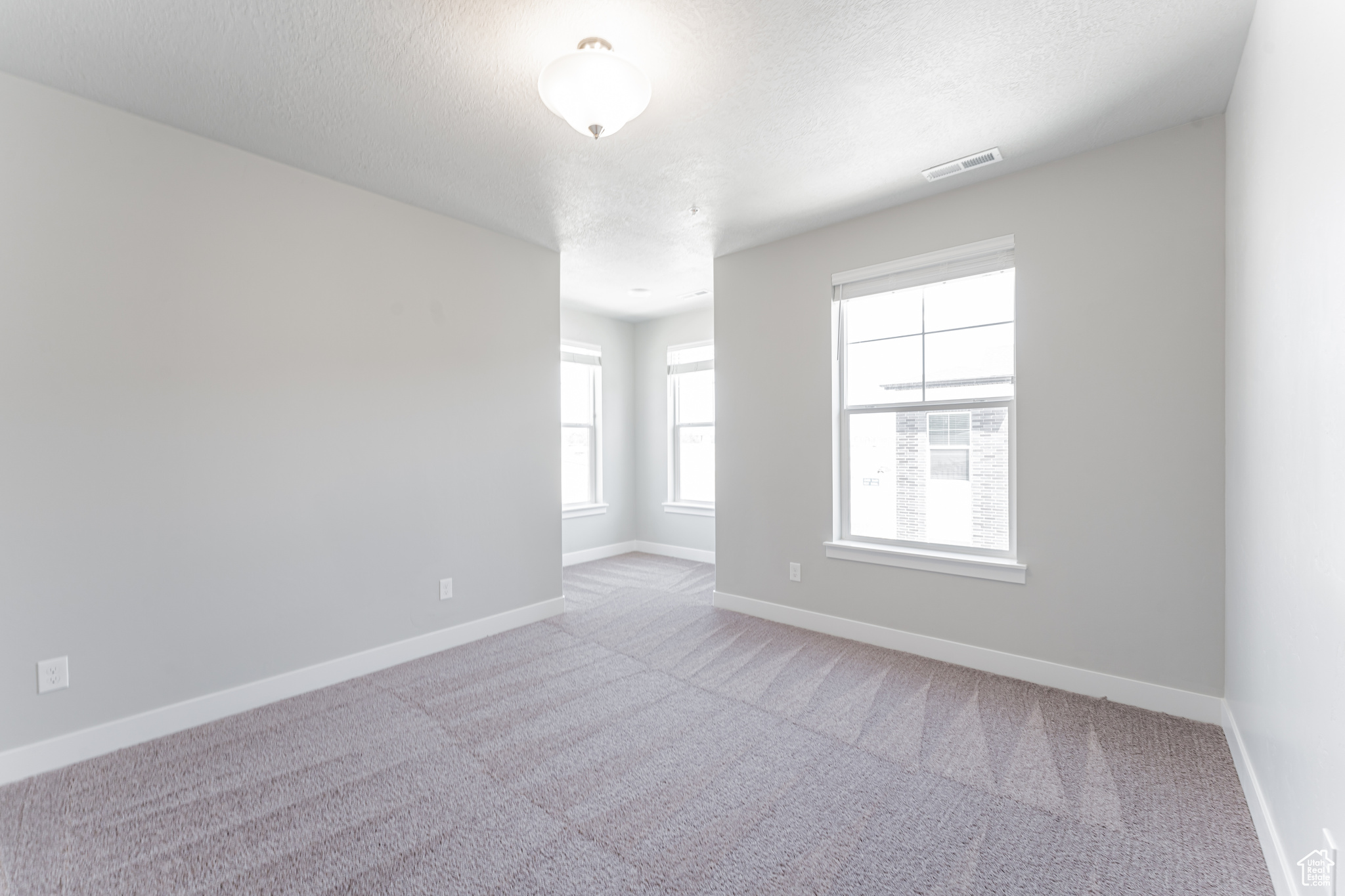 Empty room featuring light colored carpet