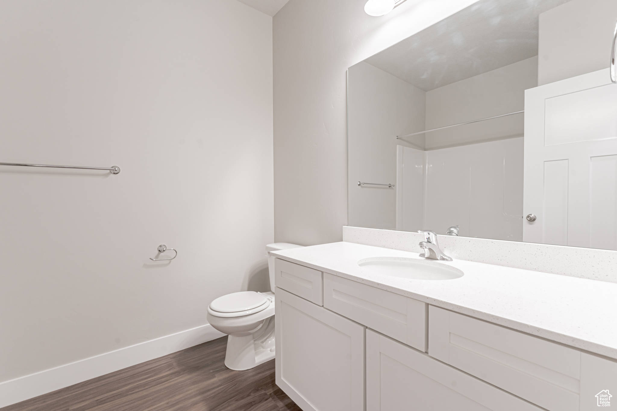 Bathroom with hardwood / wood-style flooring, toilet, and large vanity