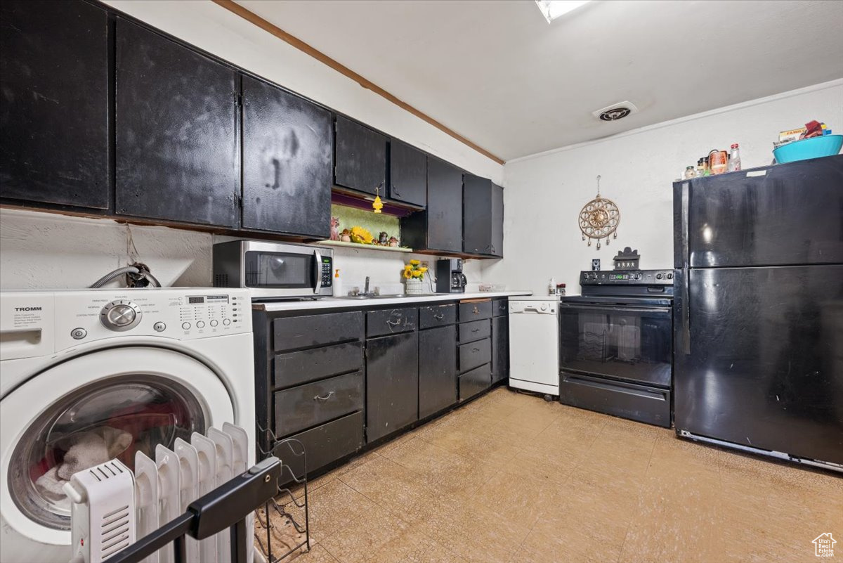 Kitchen with washer / dryer, light tile floors, and black appliances