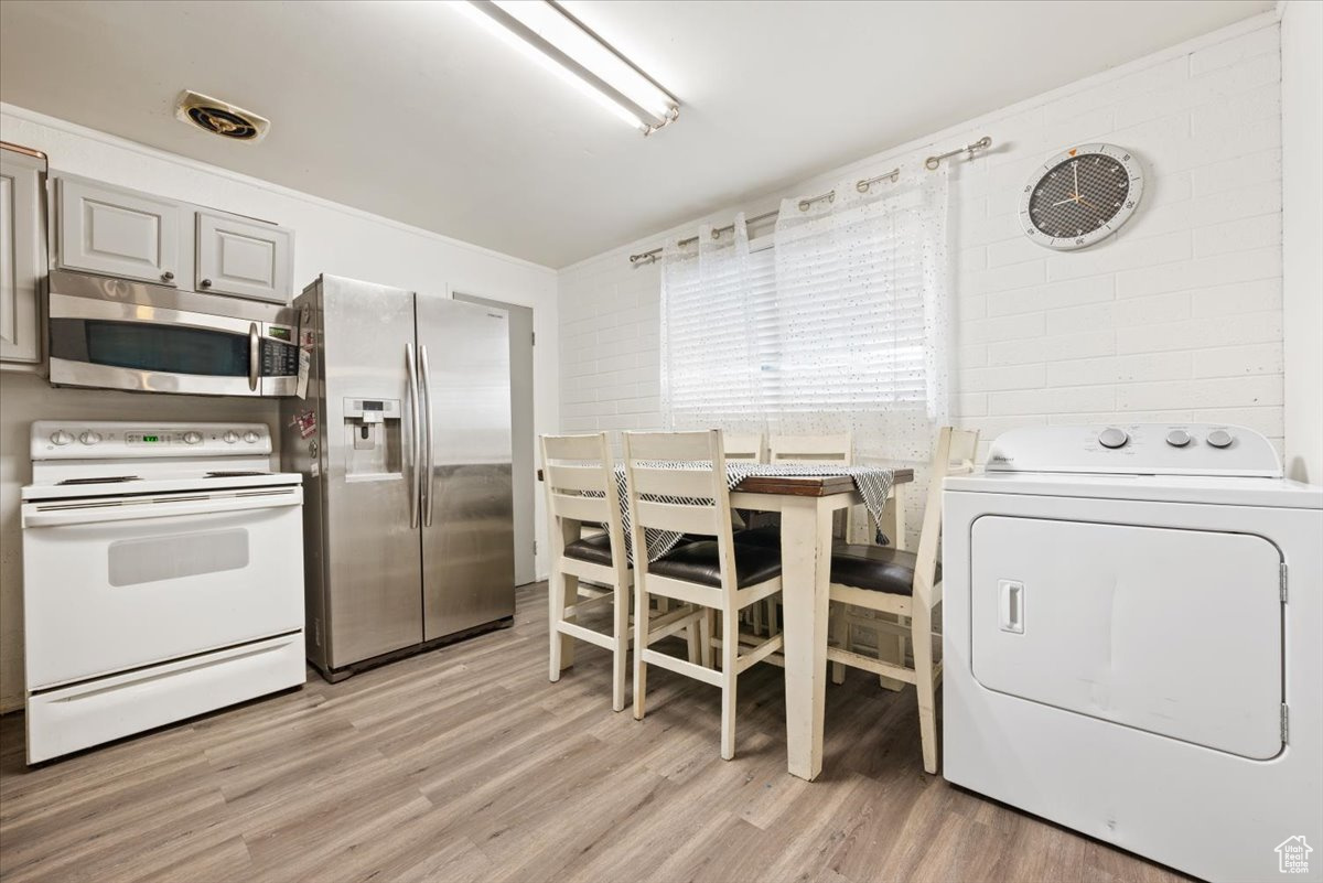 Interior space with washer / dryer and light hardwood / wood-style floors