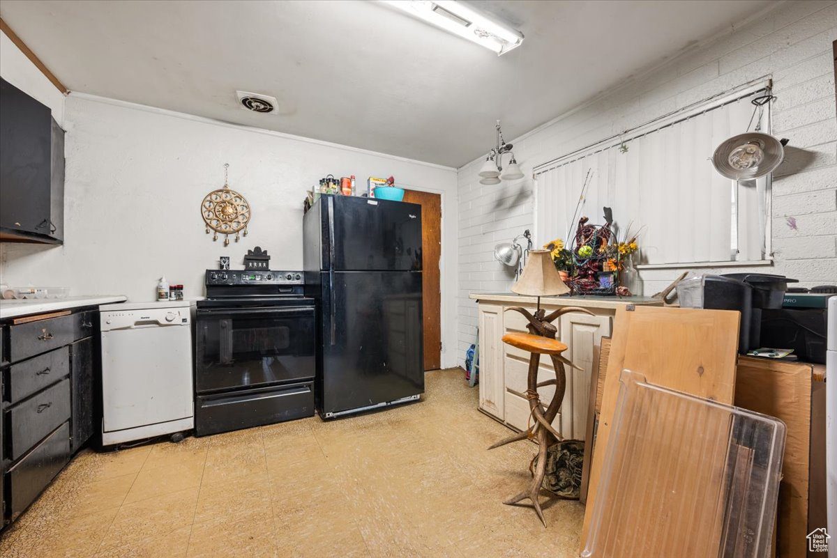 Kitchen featuring ornamental molding, light tile floors, and black appliances