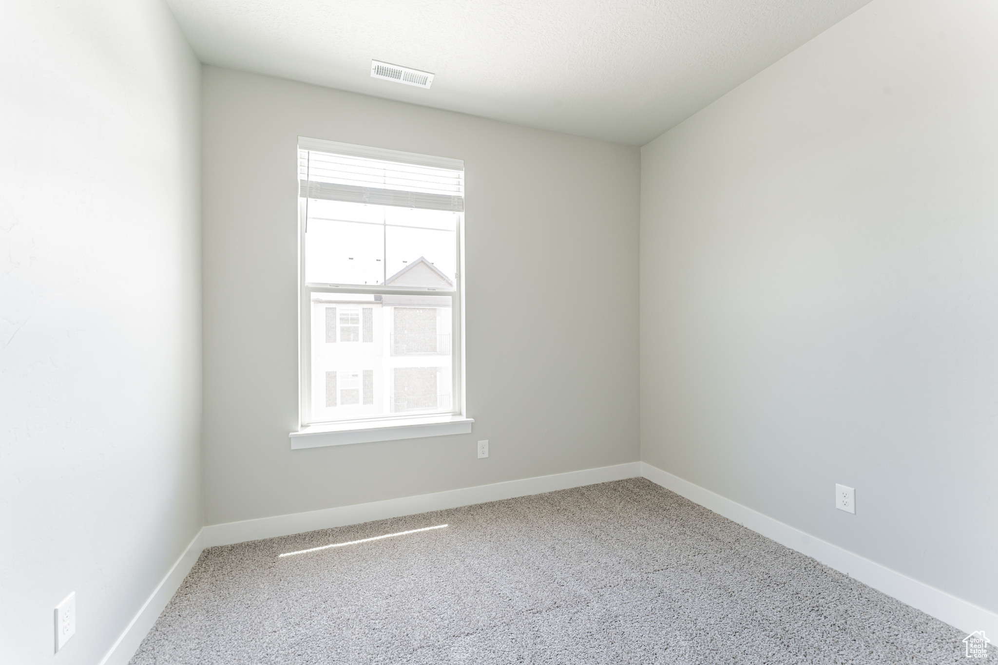 Carpeted spare room with a healthy amount of sunlight