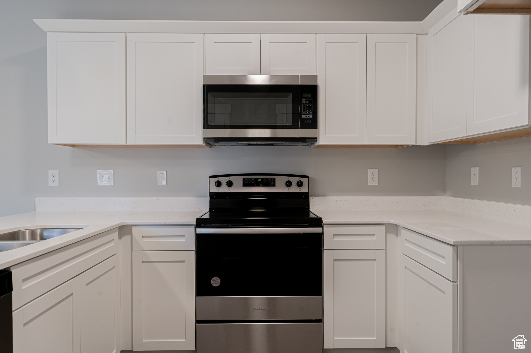 Kitchen featuring appliances with stainless steel finishes, white cabinetry, and sink