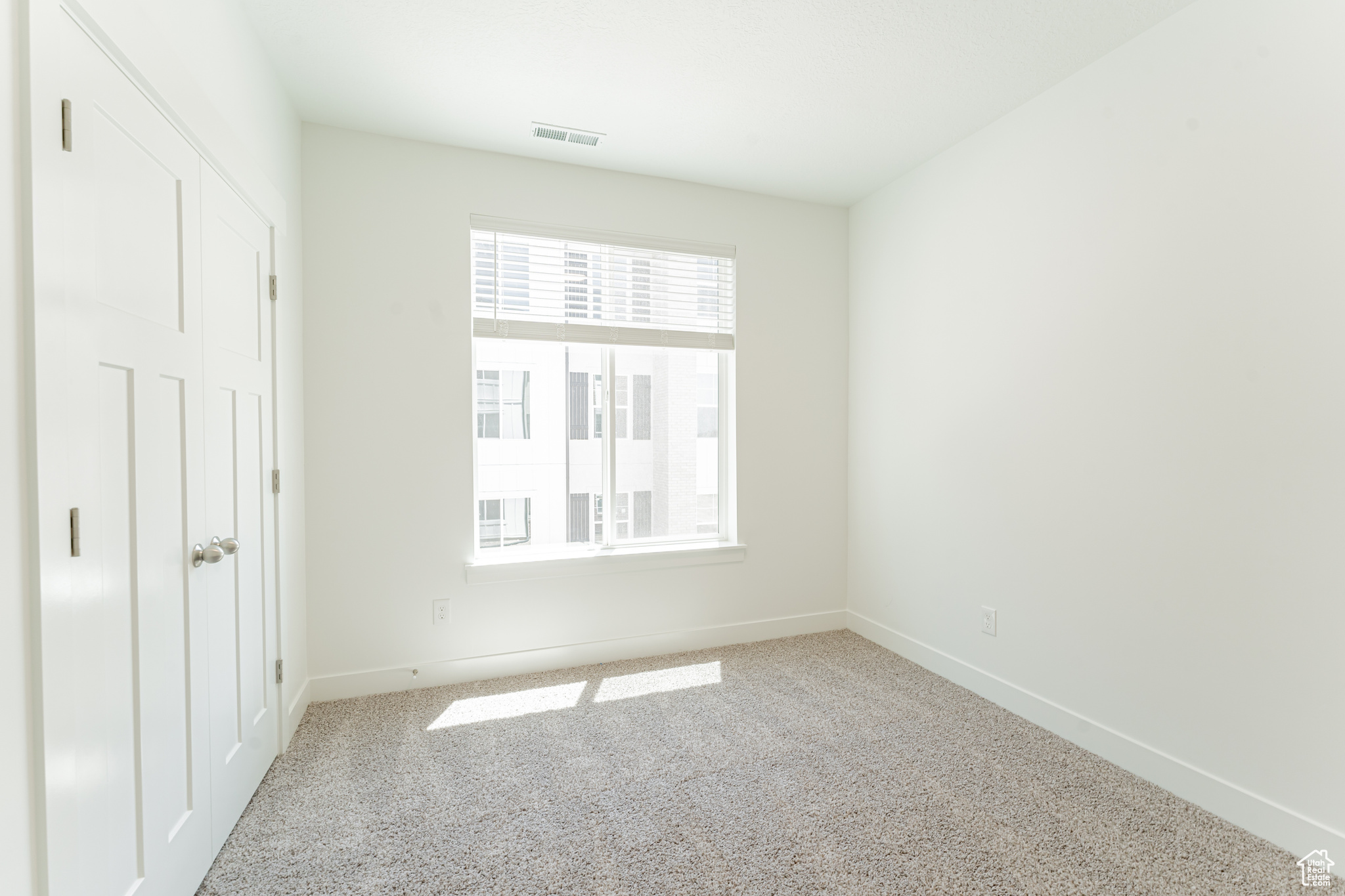 Unfurnished bedroom featuring light colored carpet