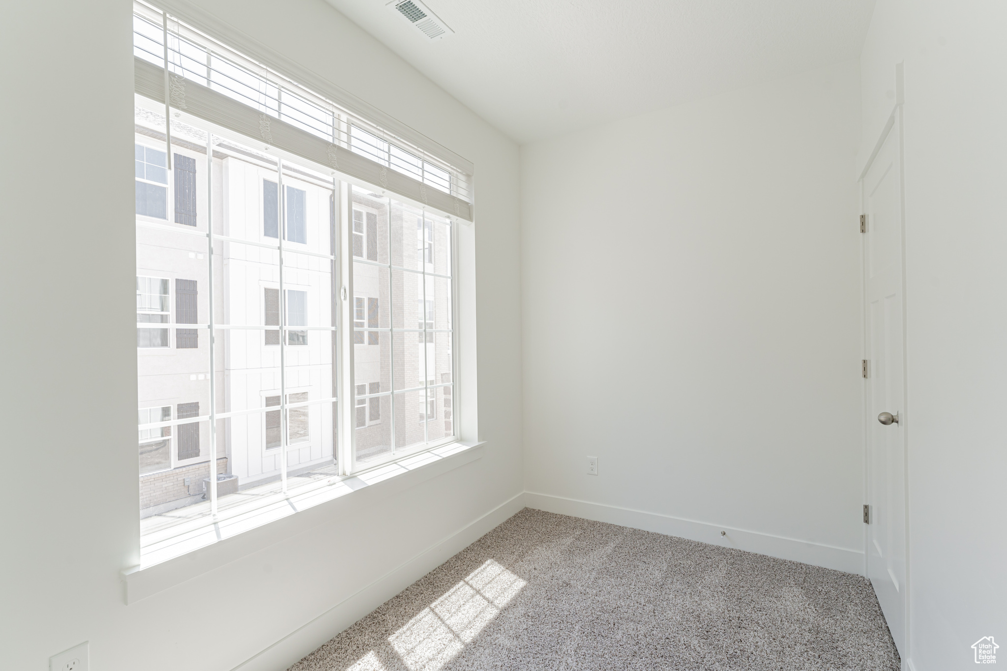 Carpeted spare room with a healthy amount of sunlight