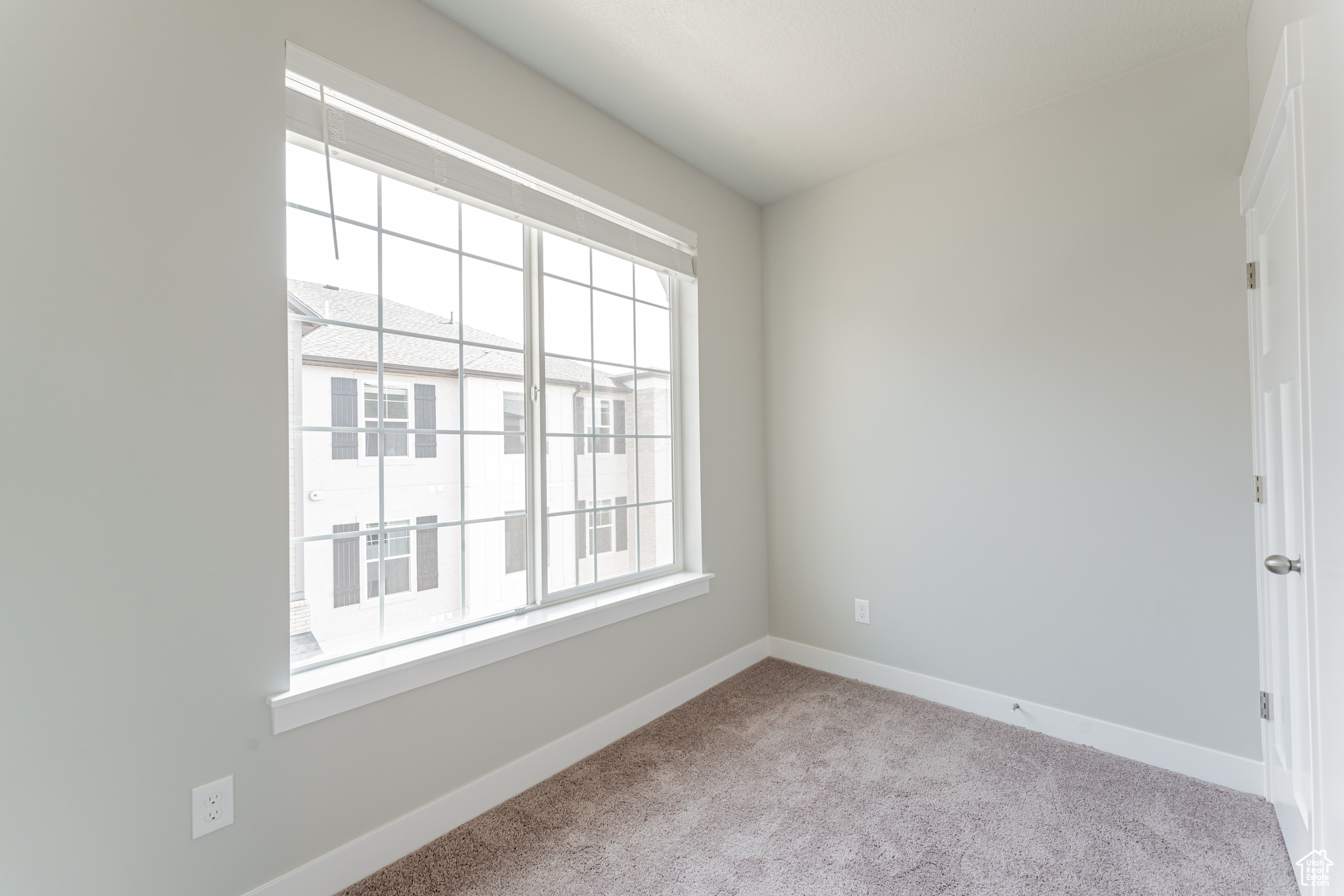 Unfurnished room featuring light colored carpet