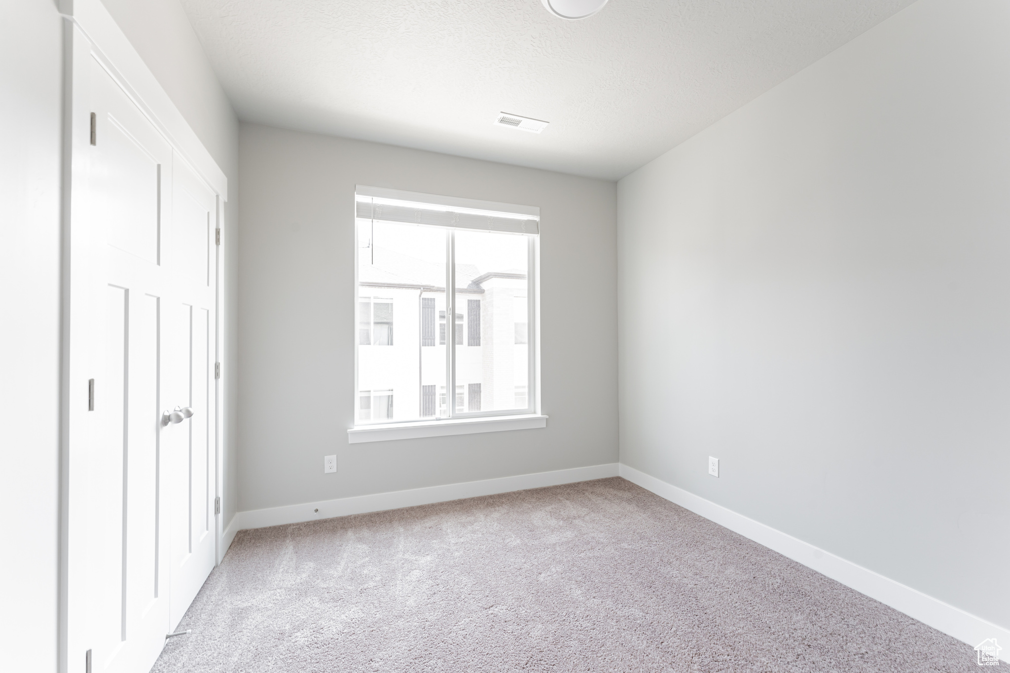 Unfurnished bedroom with light carpet