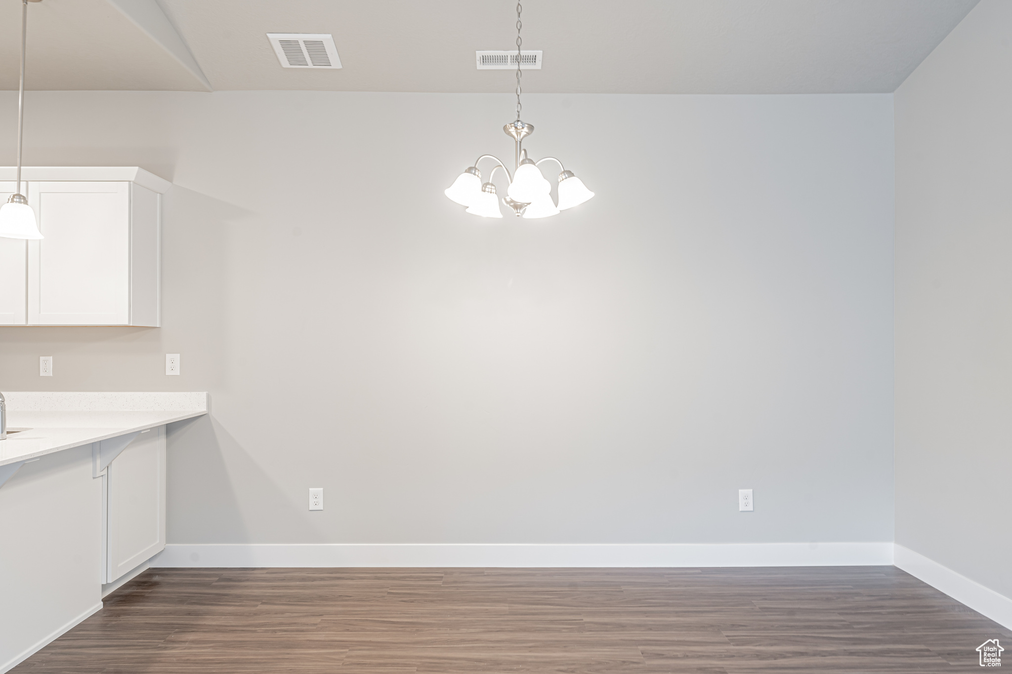 Unfurnished dining area with hardwood / wood-style flooring and a chandelier