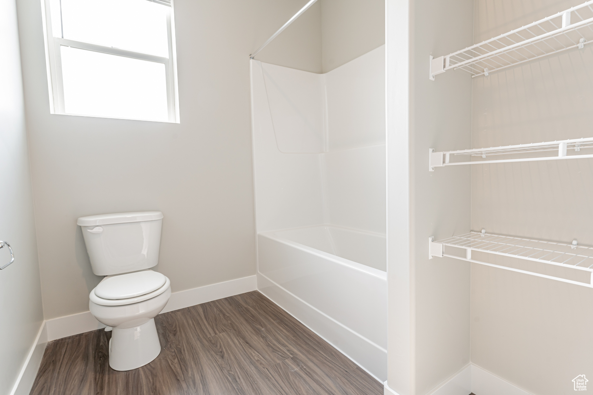 Bathroom with toilet and hardwood / wood-style flooring