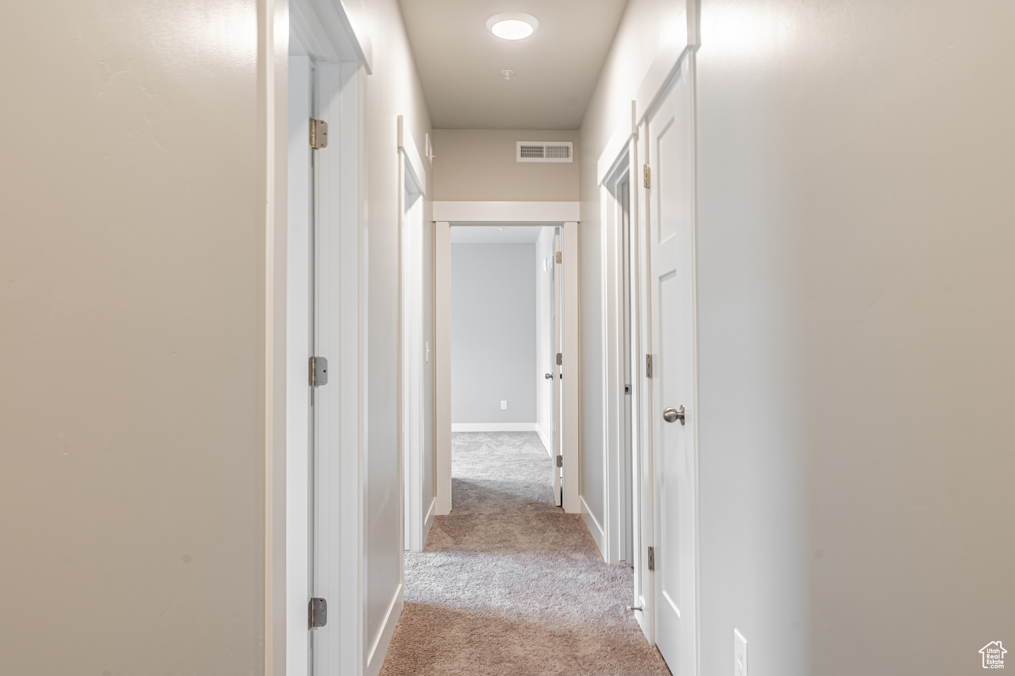 Hall featuring light colored carpet